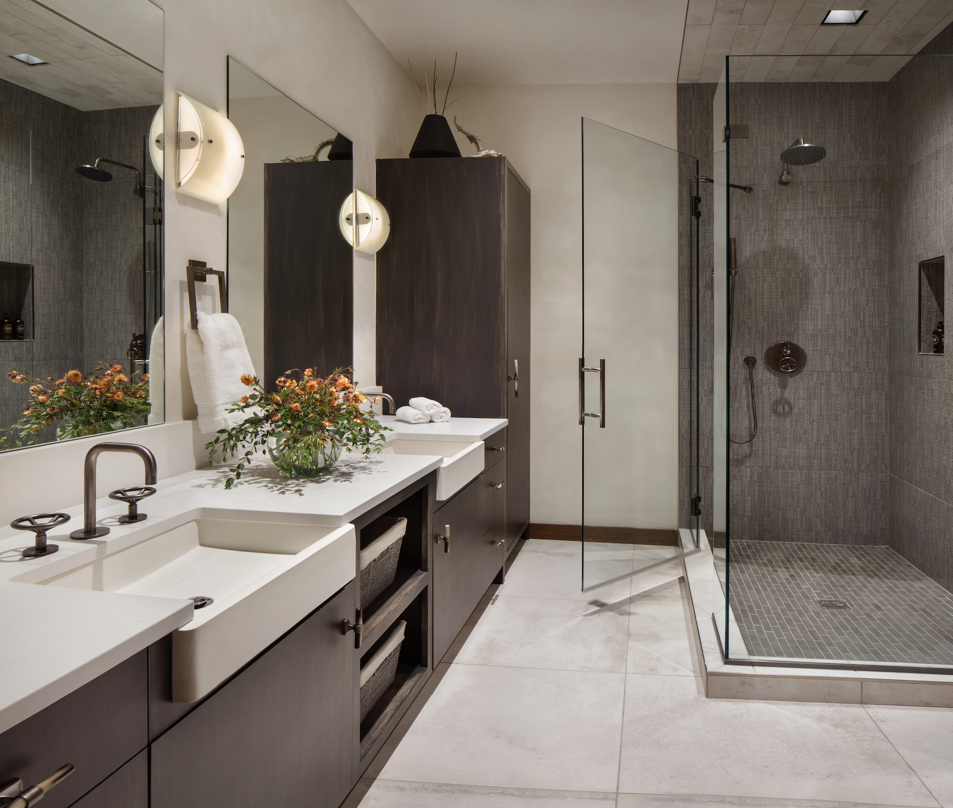Double vanity with marble countertop, wood cabinetry, and large wall mirror in the primary bathroom.