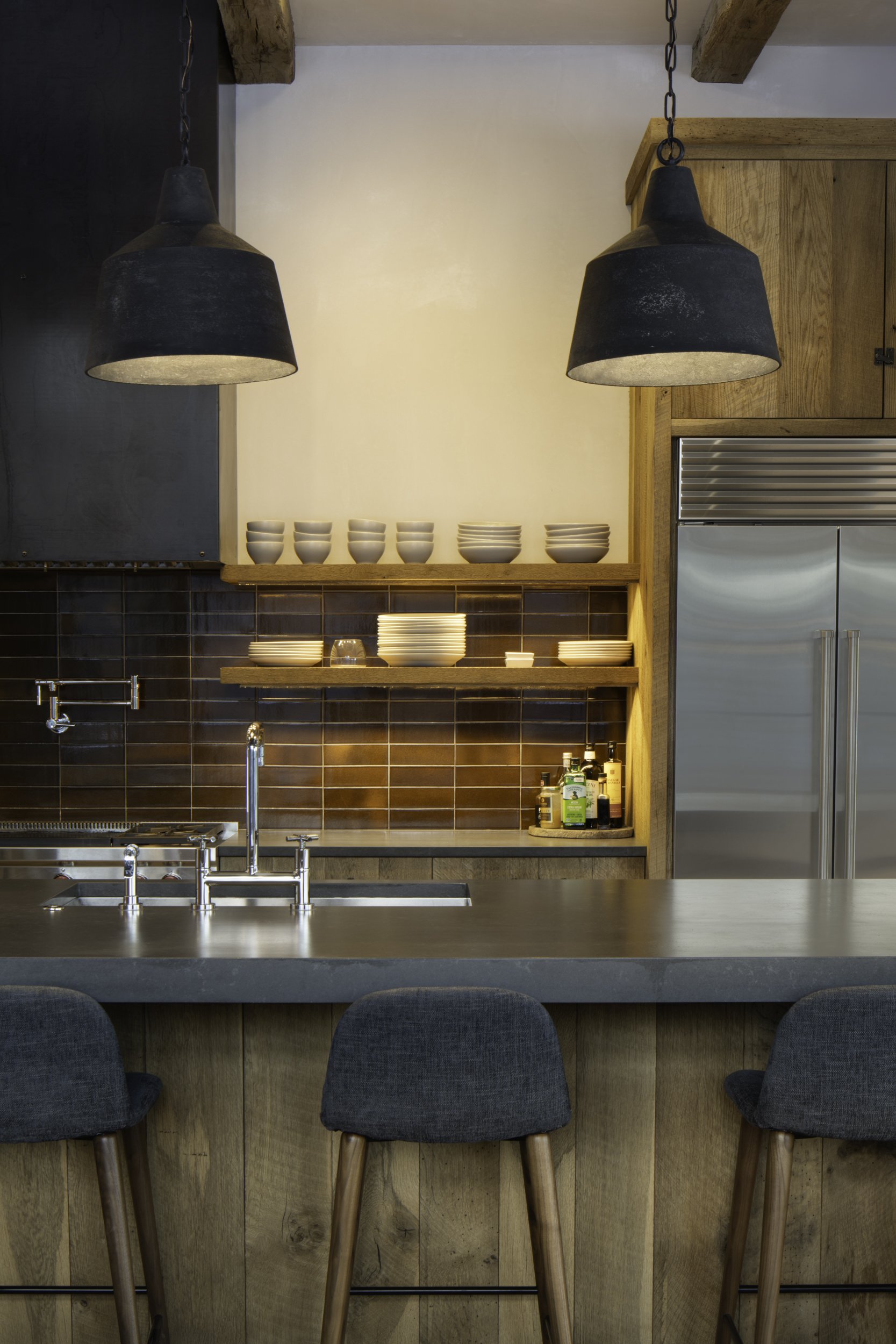 Kitchen with reclaimed wood cabinetry large island and exposed beams in Spanish Peaks, Montana
