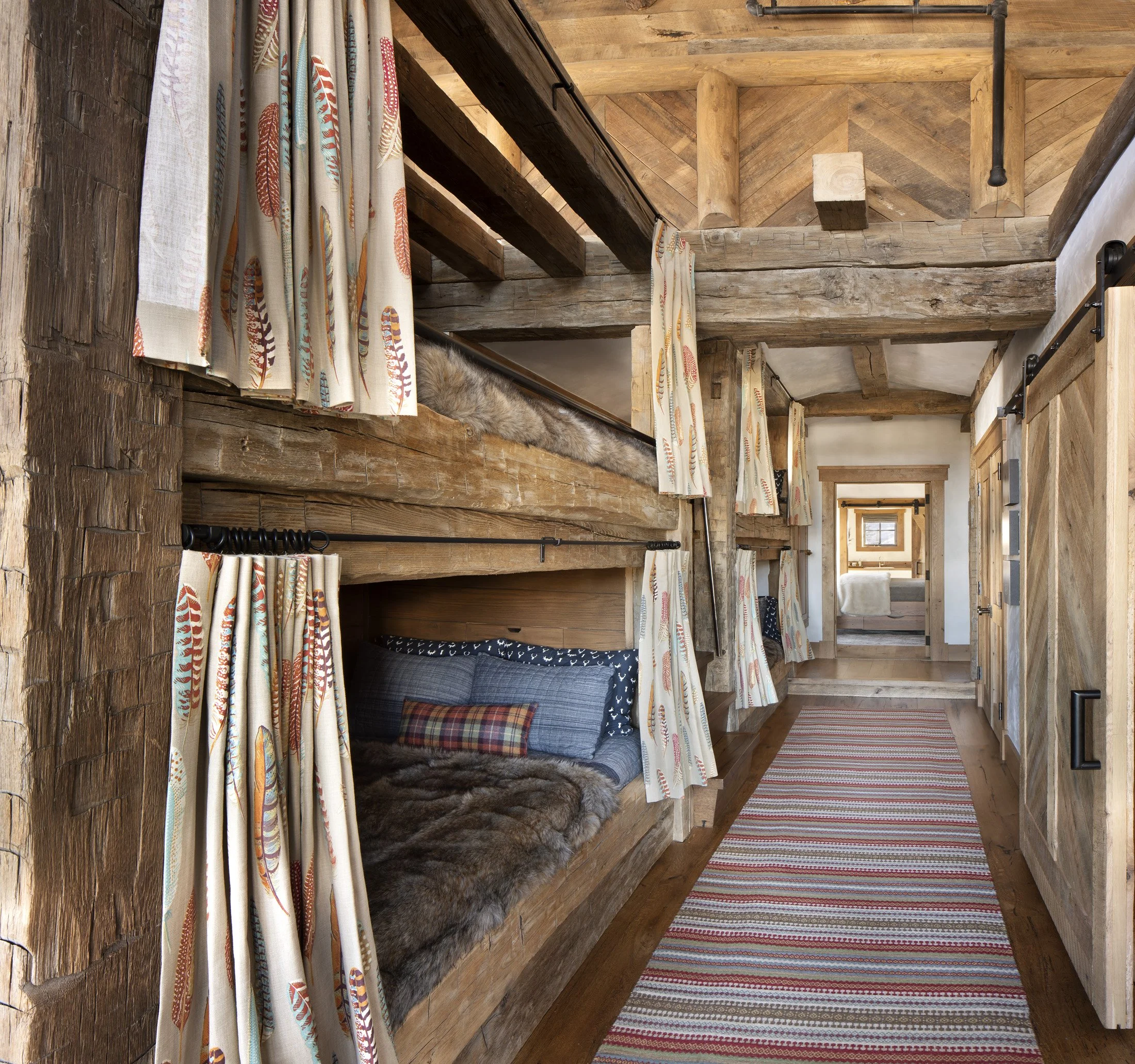 Bunk room with built-in beds and wood interior finishes in Big Sky Montana ski home