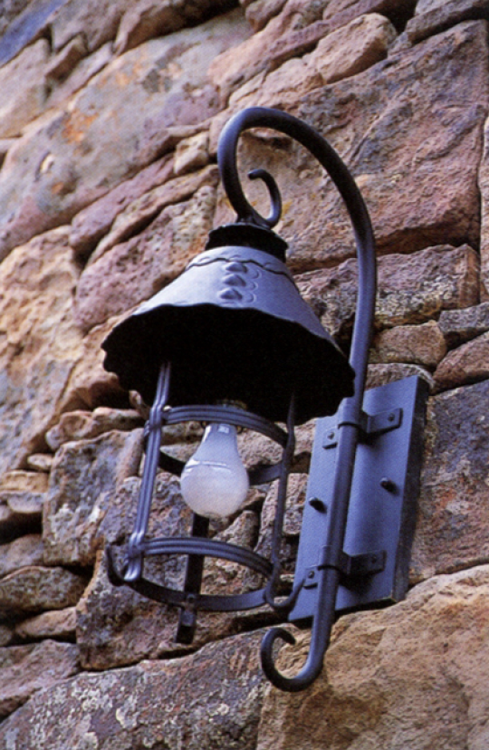 CW-12A —Forged metal exterior light fixture mounted on natural stone wall.png