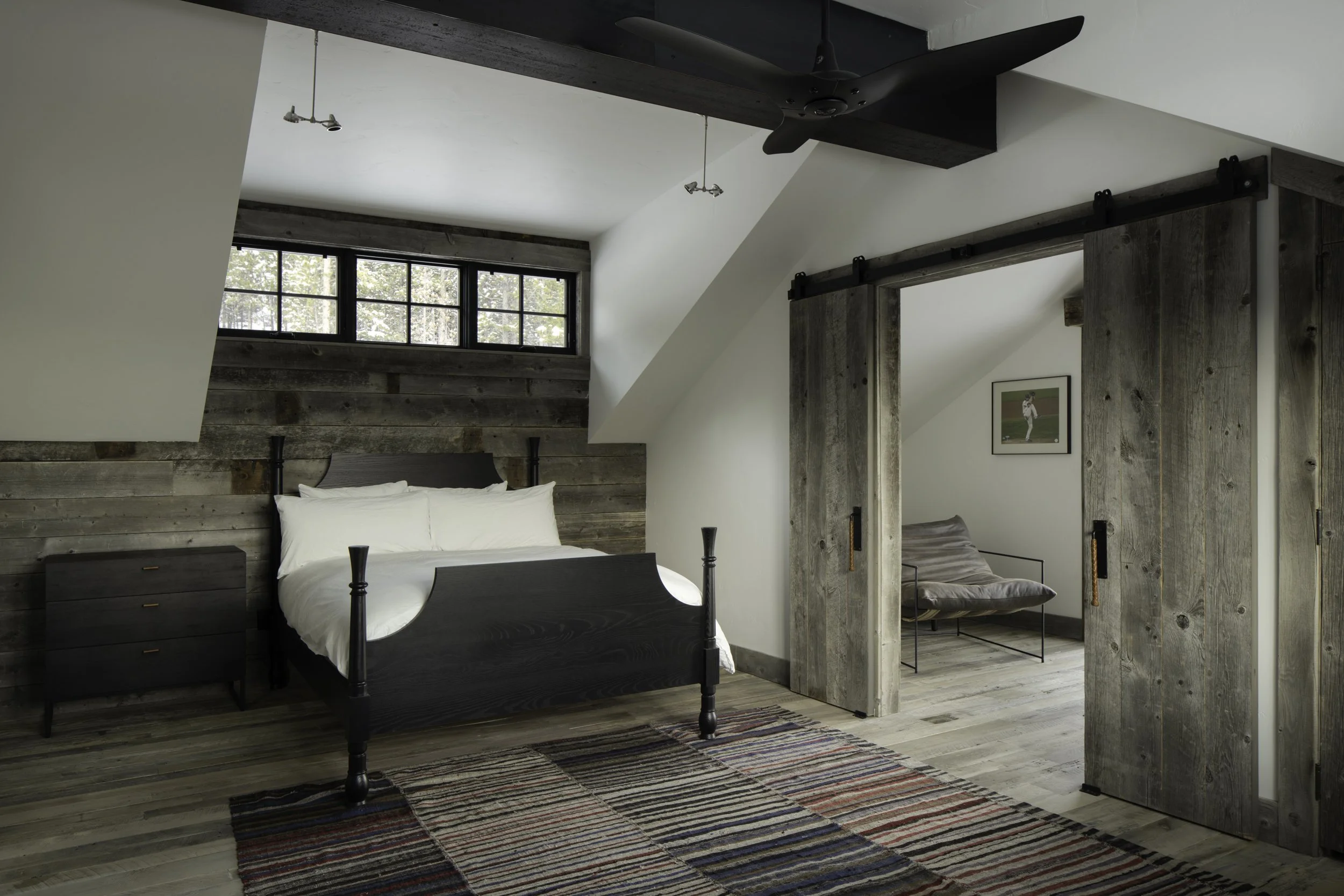 Bedroom with barn doors and reclaimed wood detail in Big Sky Montana