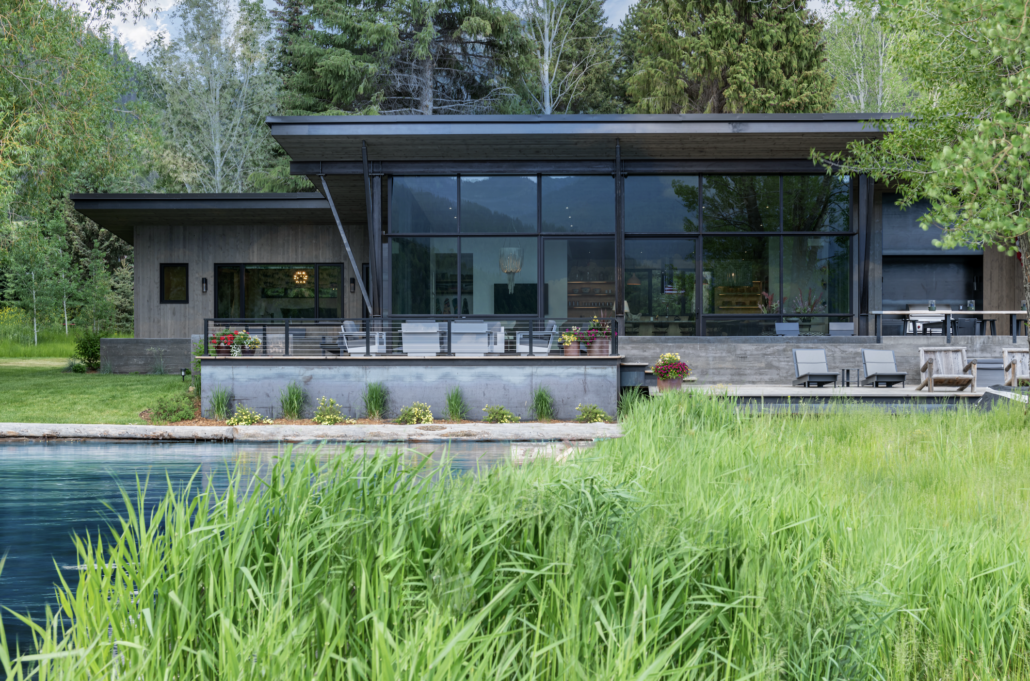 Modern lake house exterior with glass facade and wood siding at Hebgen Lake Montana