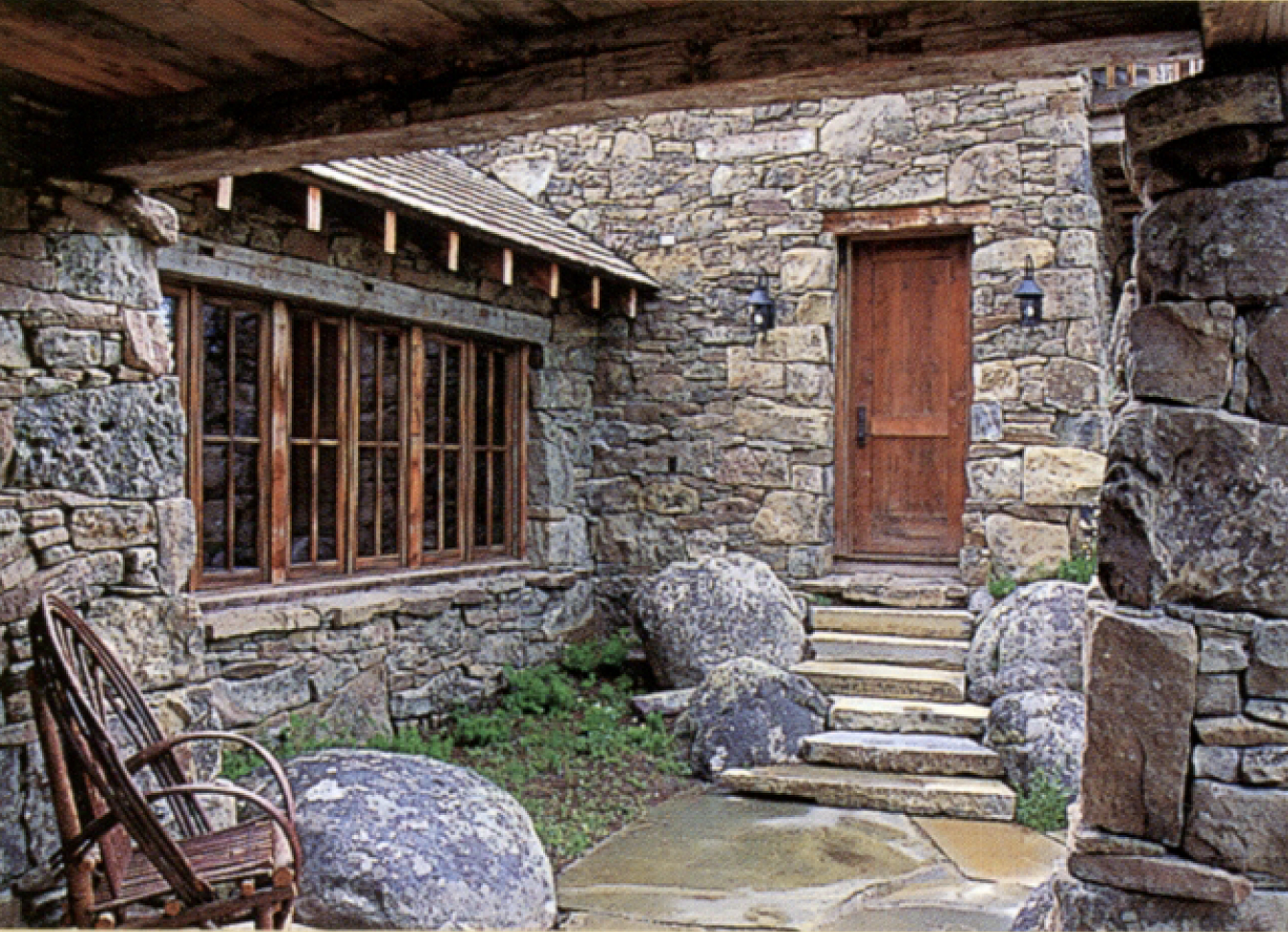 CW-08A —Stone entry courtyard with timber door, divided light windows, and natural boulder landscaping.png