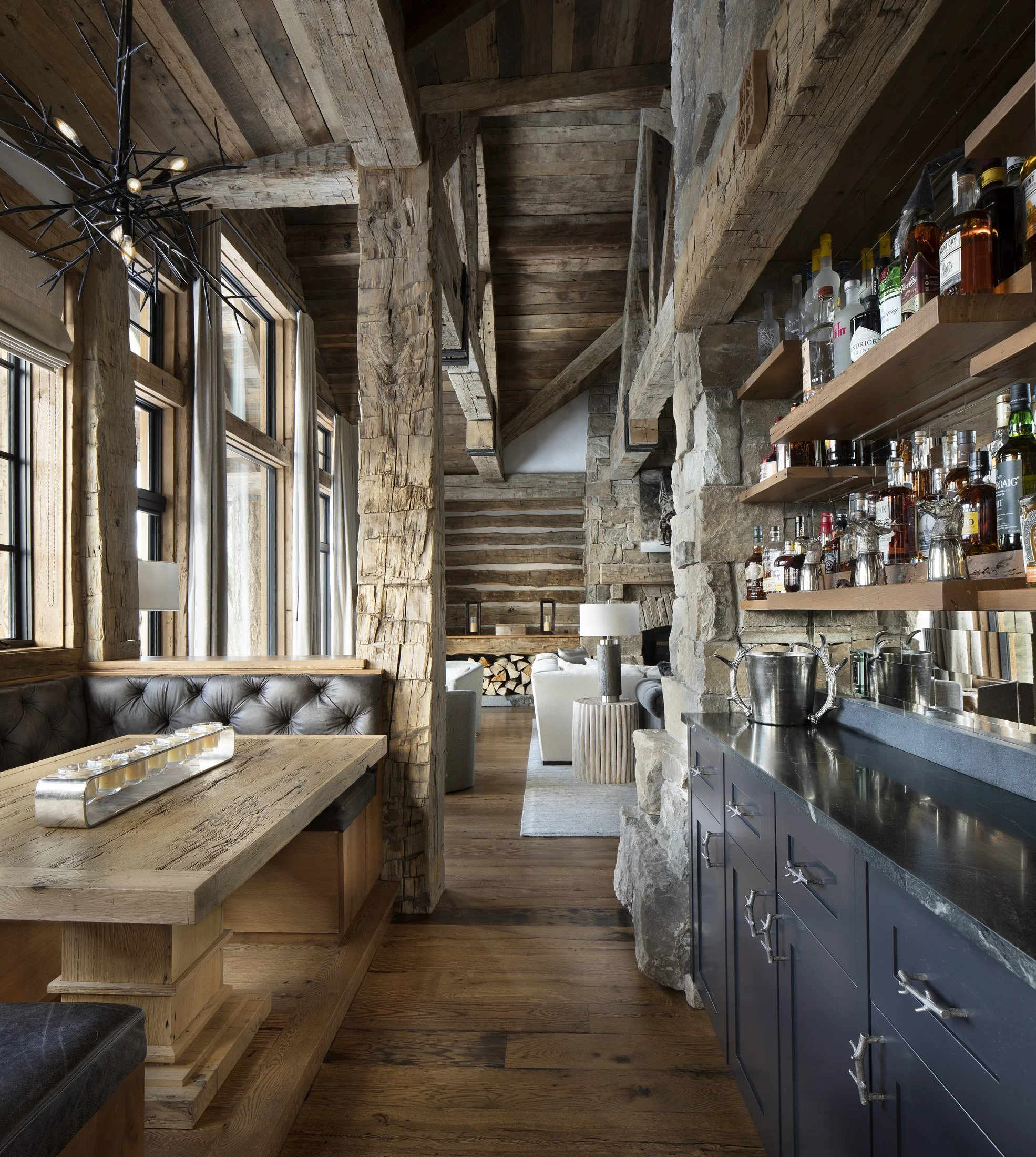 Built-in bar with stone walls, wood shelving, and cabinetry