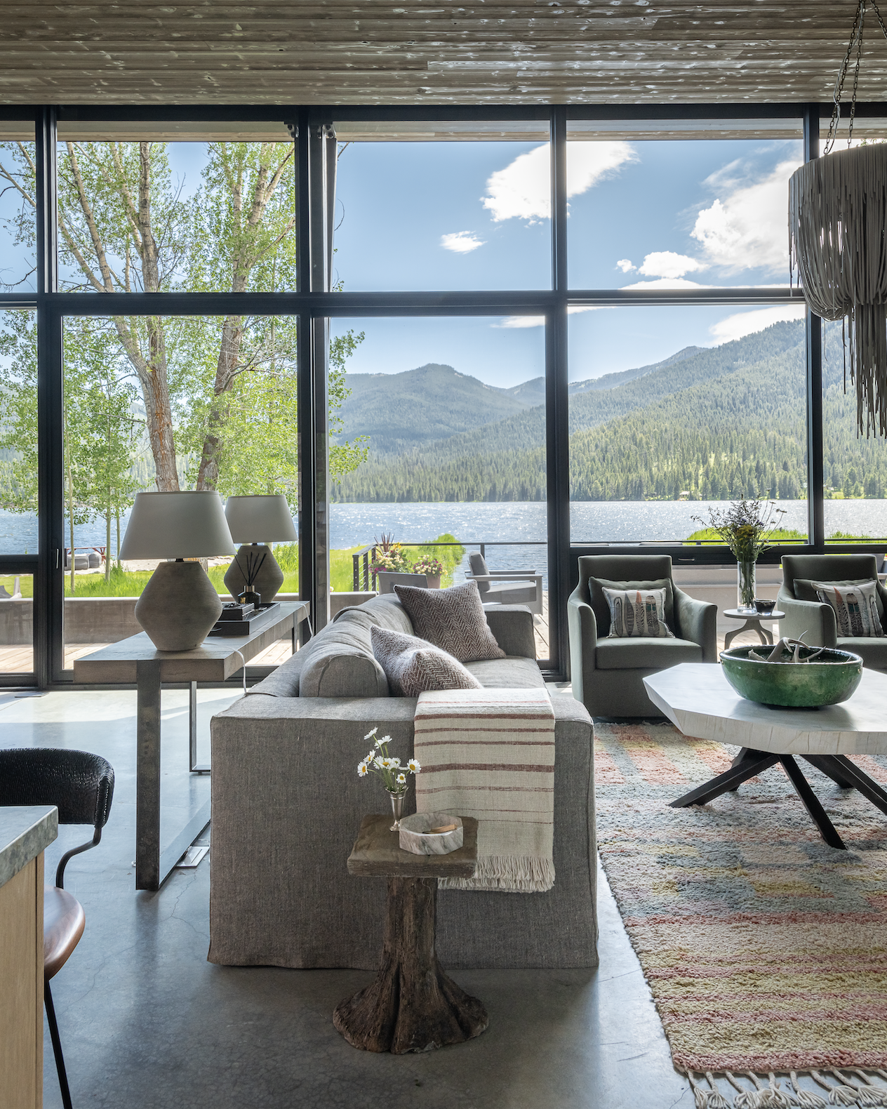 Open living space with large windows framing views of Hebgen Lake and mountains