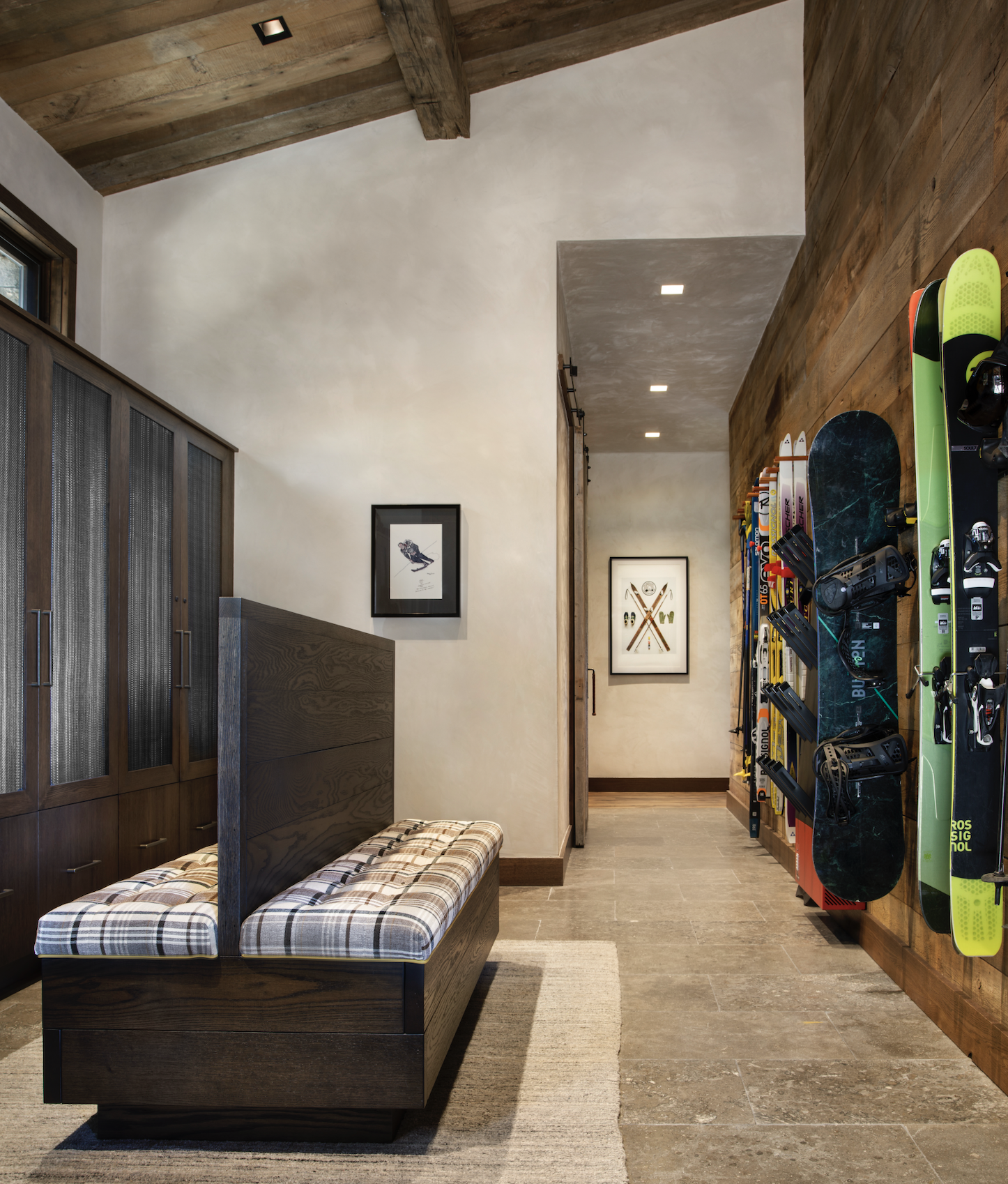 Ski room with built-in storage, bench seating, and wall-mounted ski equipment.