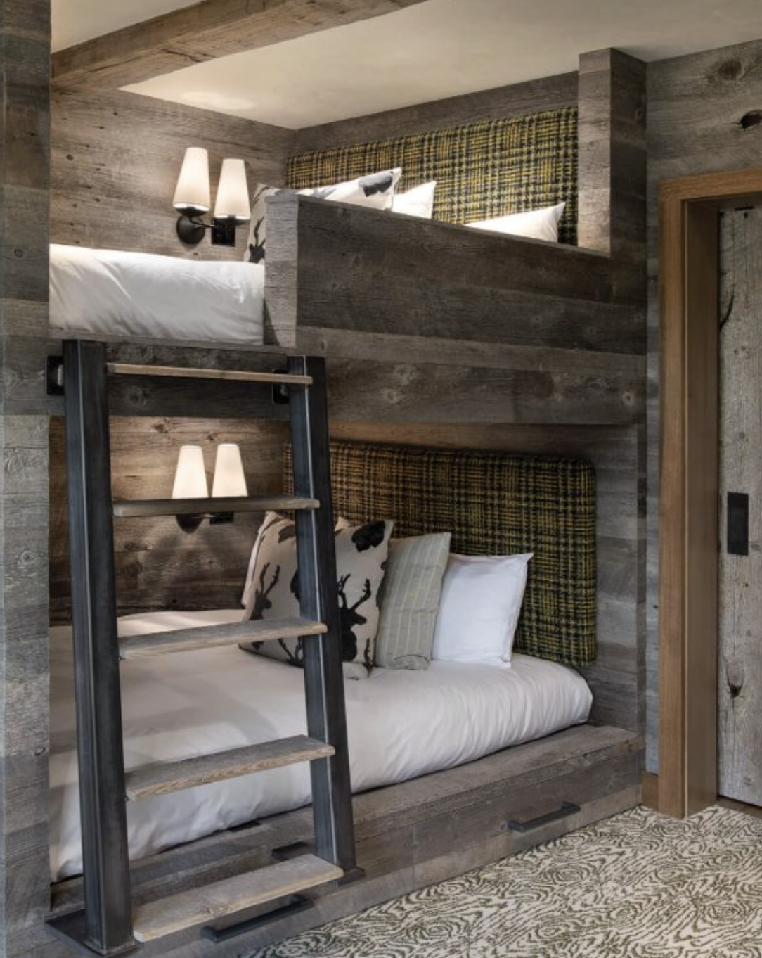 Custom bunk room with built-in wood bunks, upholstered headboards and integrated ladder.
