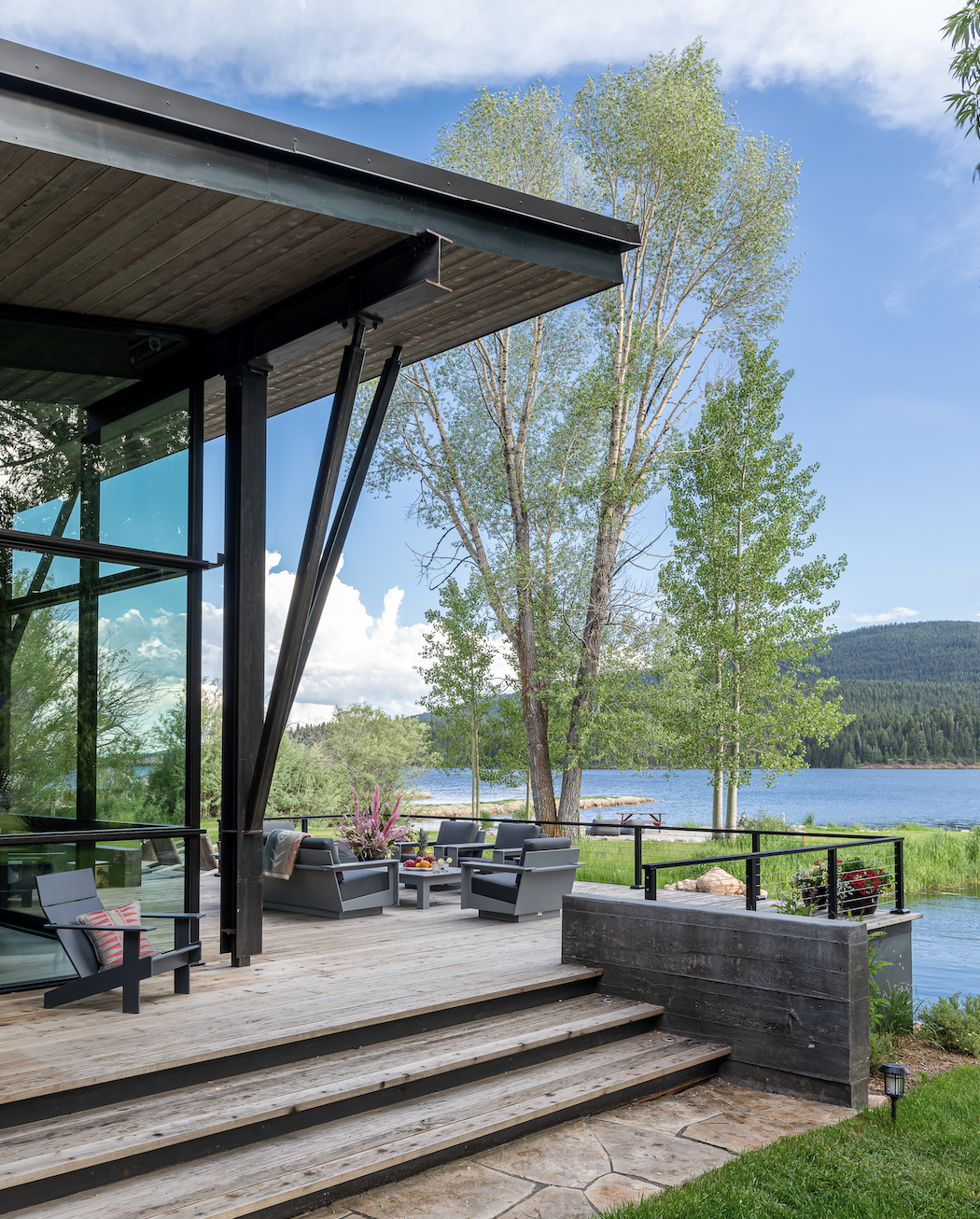 Outdoor seating area with lake views and modern structure at Hebgen Lake home