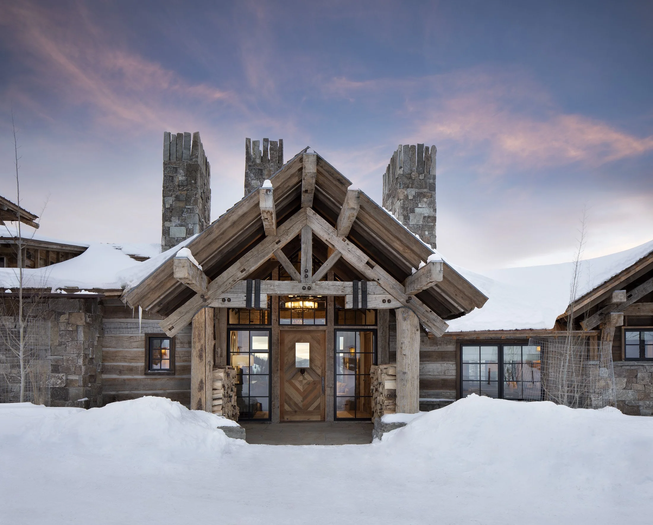  Front entry with heavy timber trusses and stone columns at ski-in ski-out home in Big Sky Montana