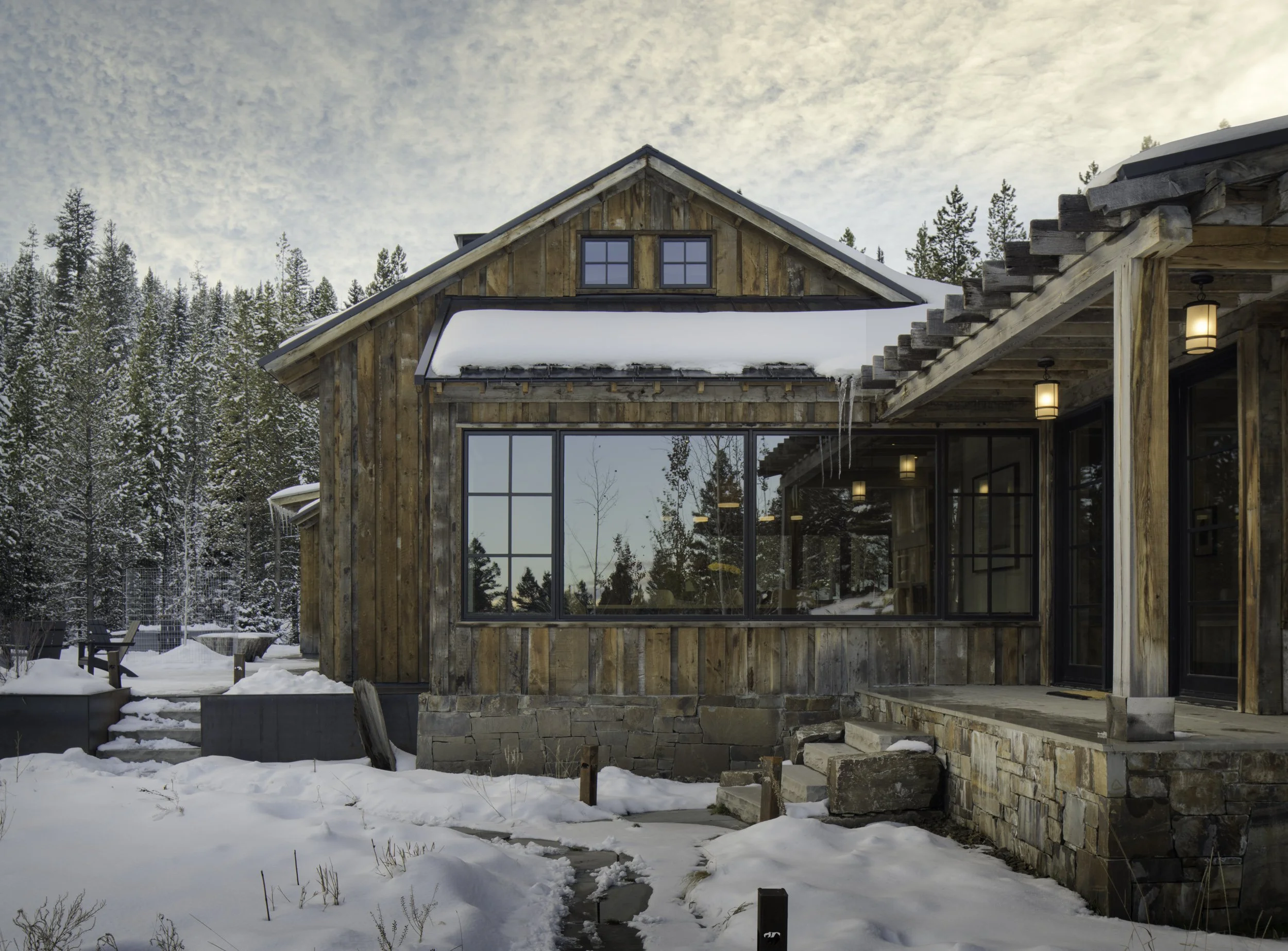 Covered entry with timber framing and stonework in Spanish Peaks Big Sky Montana