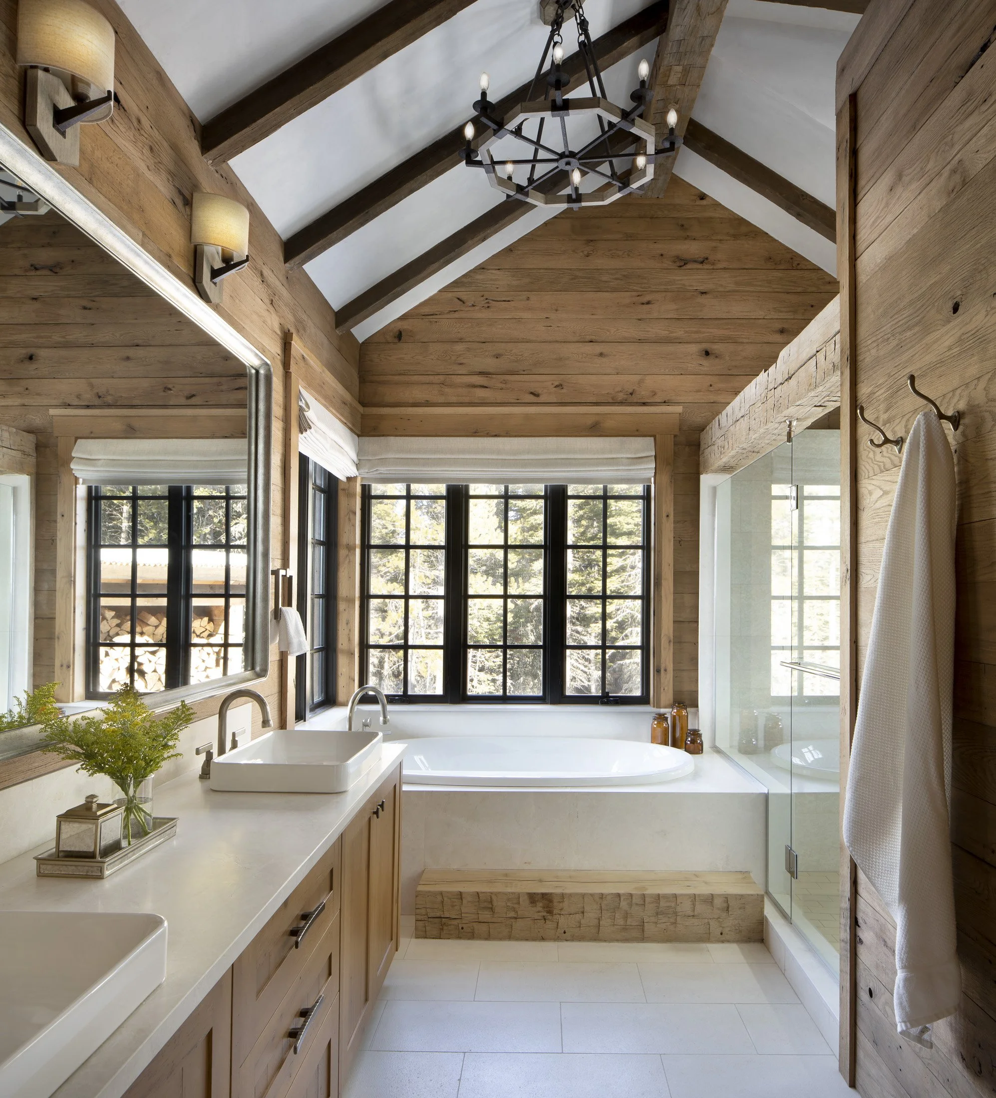 Bathroom with soaking tub, wood finishes, and large windows in mountain home at Big Sky Montana