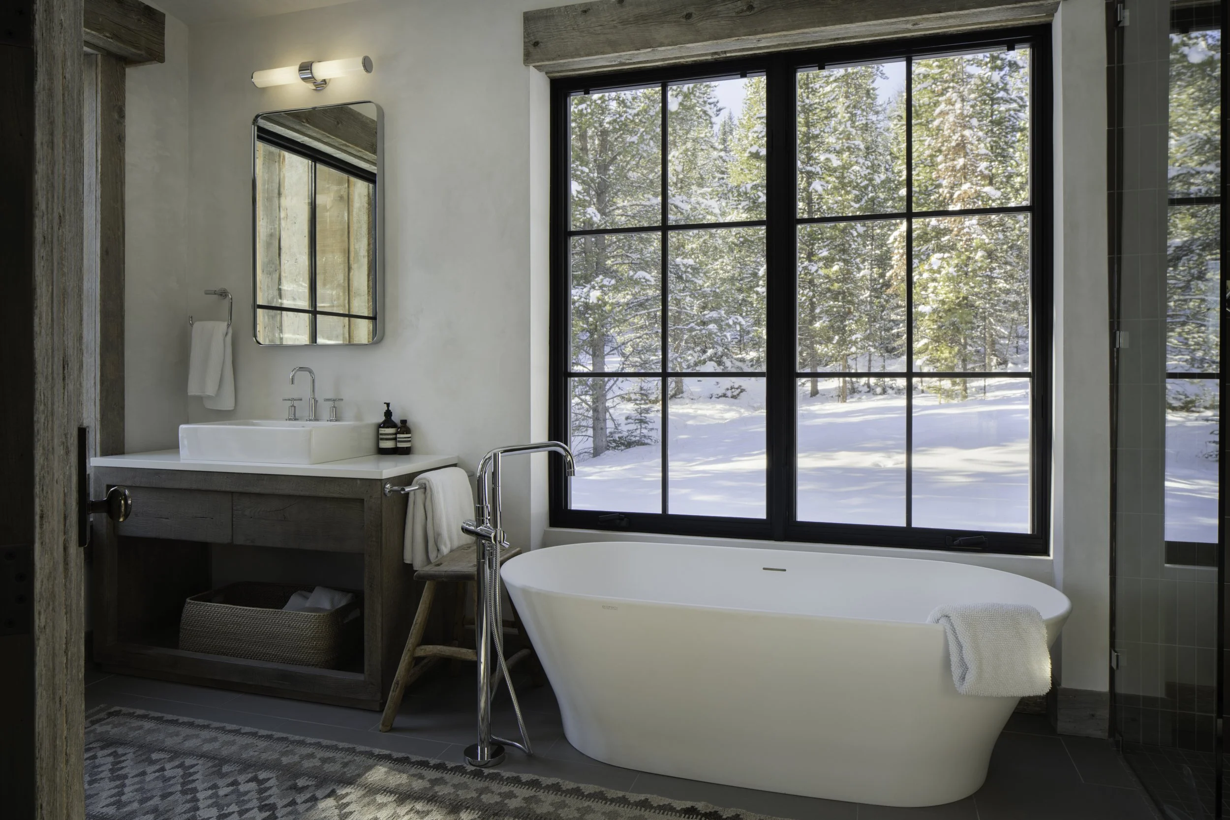 Bathroom with soaking tub and large window views in Big Sky Montana