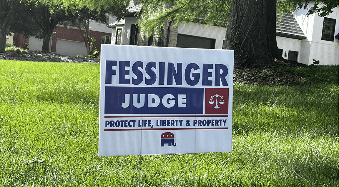 Political yard sign supporting Fessinger Judge, with the slogan "Protect Life, Liberty & Property," and icons of scales of justice and an elephant.