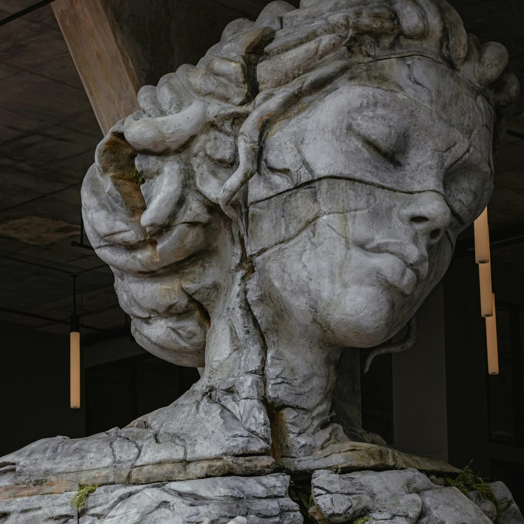 An image of a femal statue with cracks in the design of her face and chest.