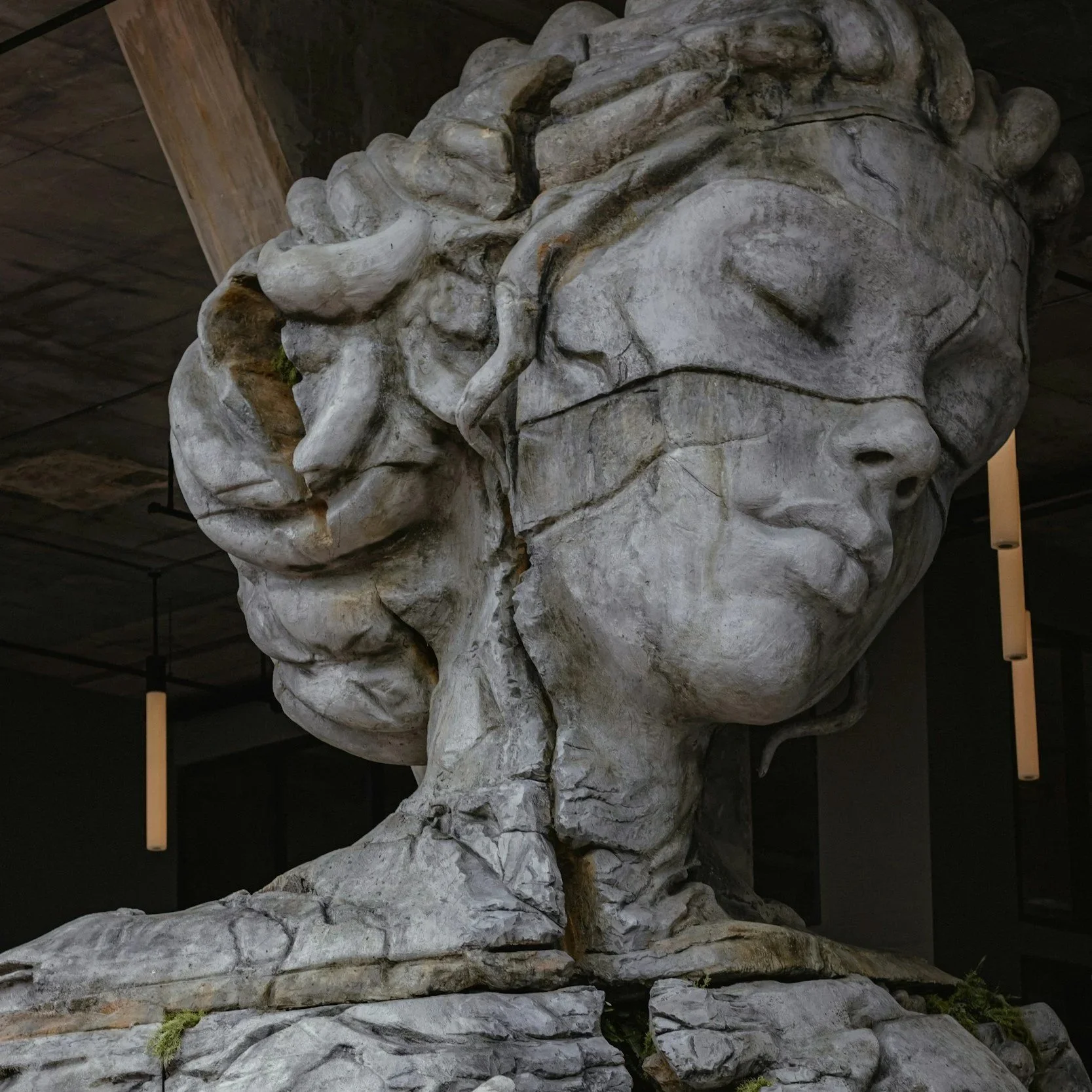 An image of a femal statue with cracks in the design of her face and chest.