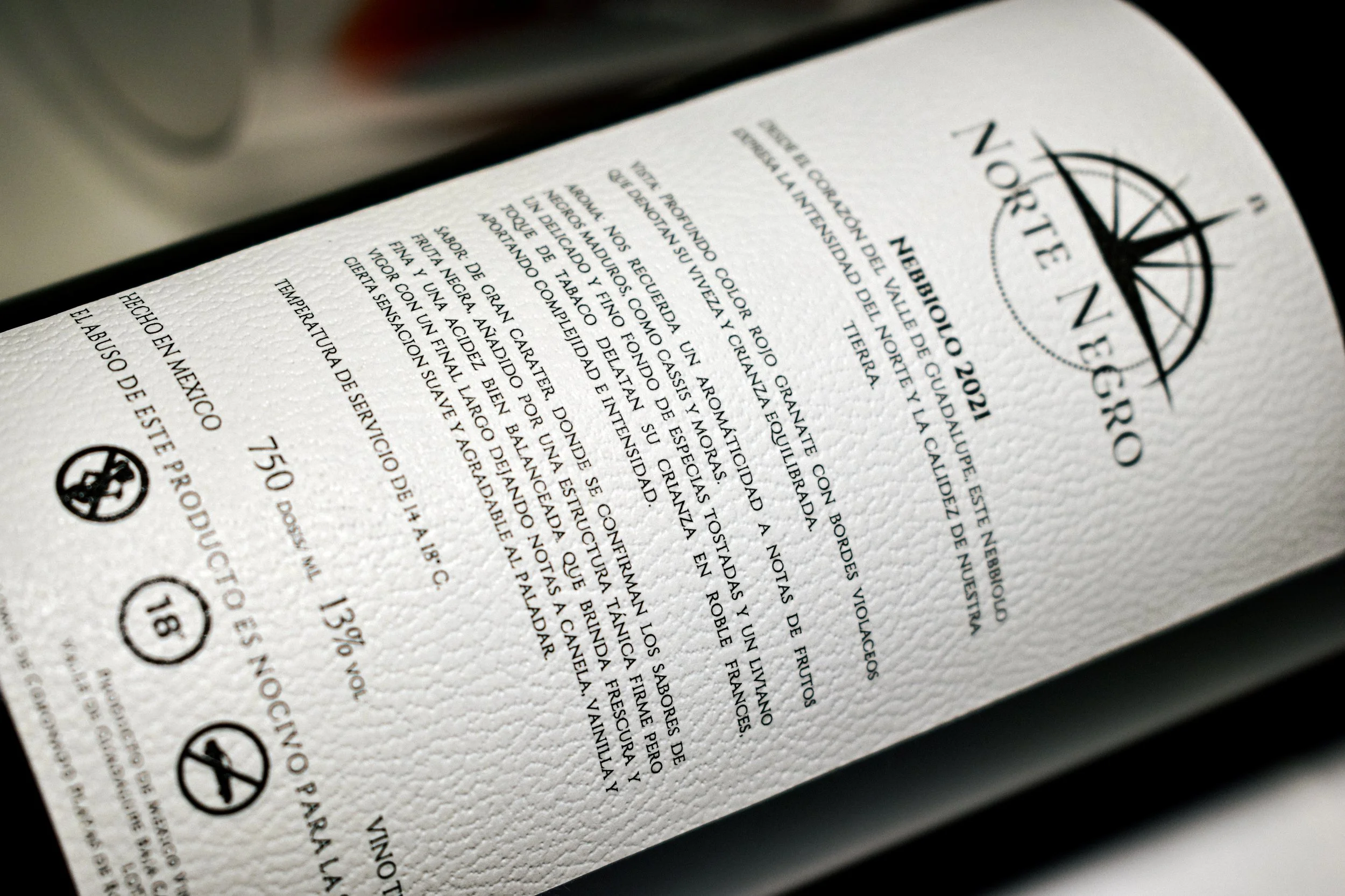 Etiqueta de vino con información sobre el origen, descripción y características, incluyendo logo y advertencias de consumo.