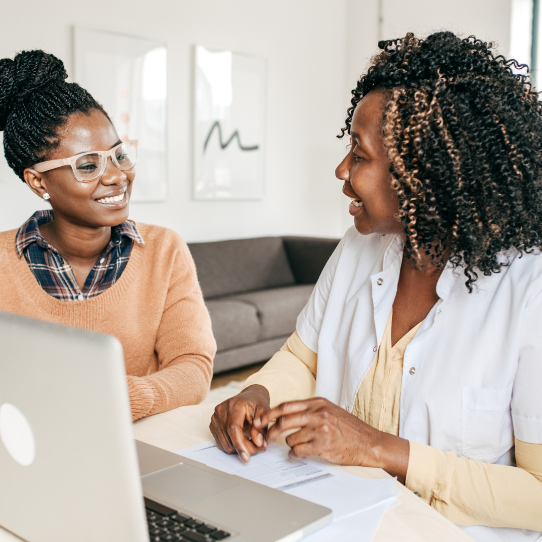 Two black women collaborating on a laptop