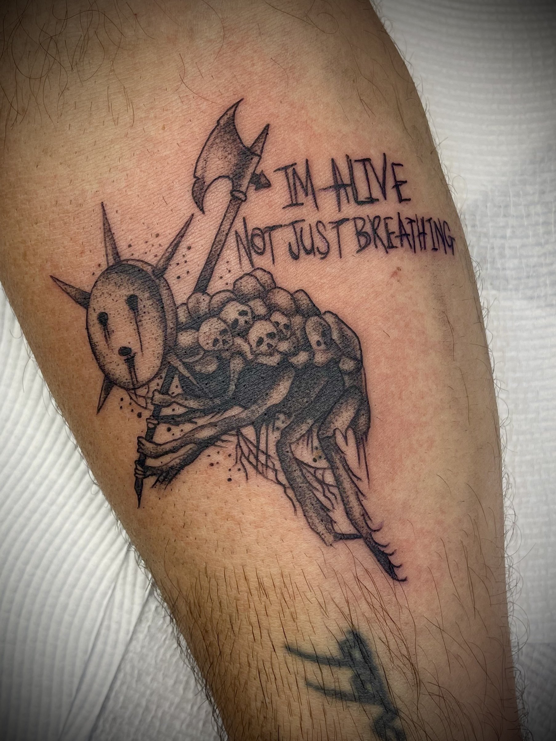 Black and grey skull tattoo with axe designed by Leasy Tattoo