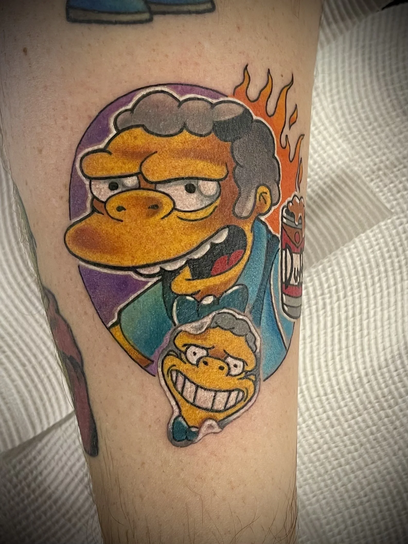 Tattoo of the Simpsons characters Bart and Lisa Simpson on person's arm, with bright colors and cartoon style.