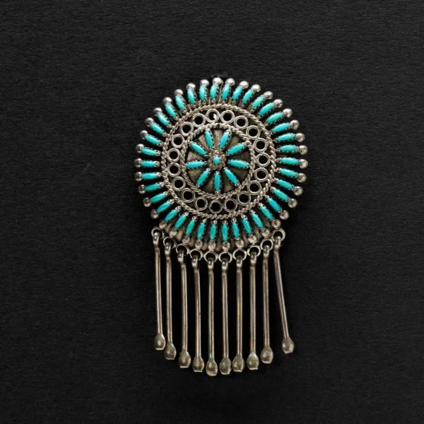 A Octavius Irma Seowtewa Pin Pendant Silver brooch with turquoise stones and dangling silver rods on a black background.
