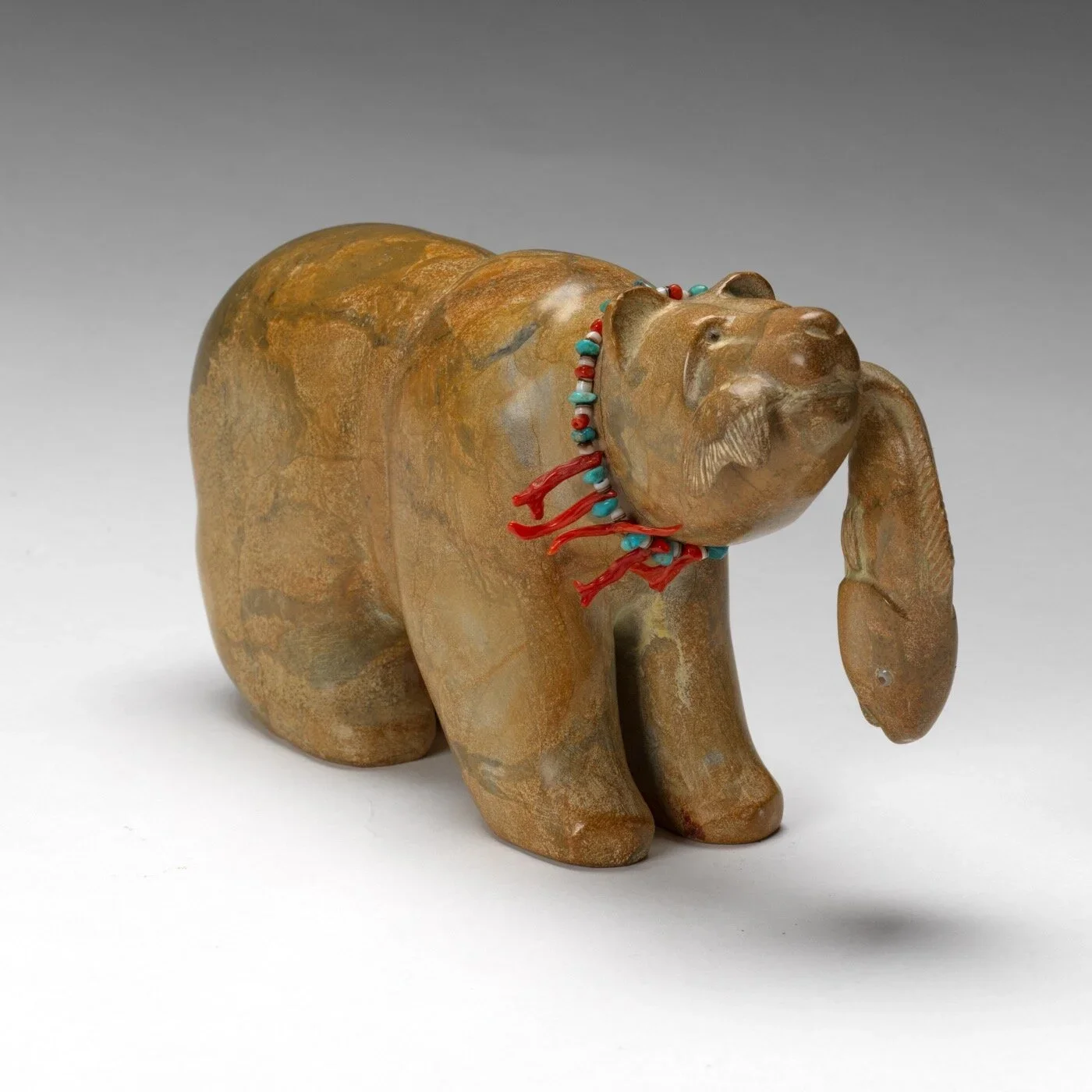 Artist Bowannie carved a Bear with Fish wearing a coral Necklace.