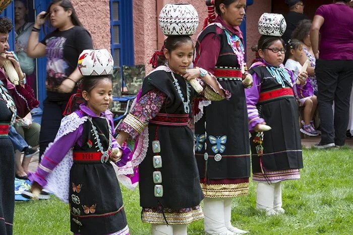 Young girls in traditional Zuni clothing holding hands during at the Zuni Show.
