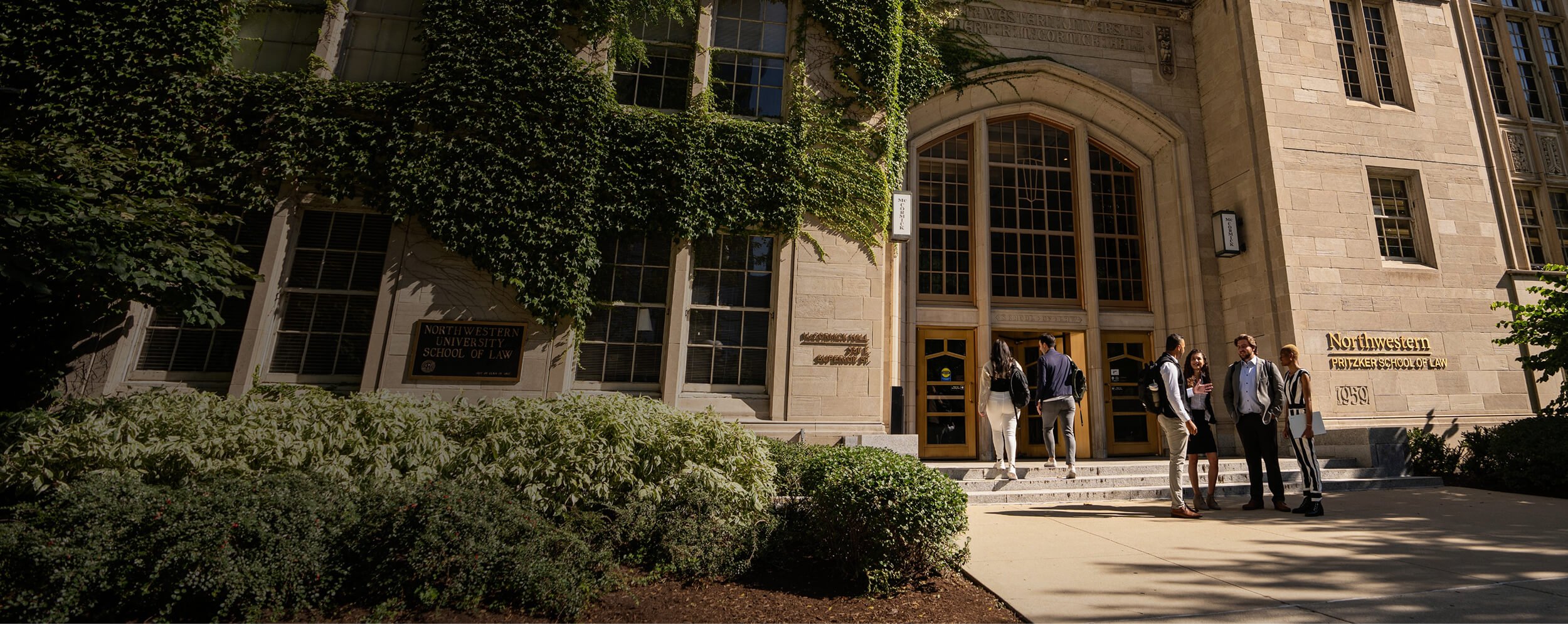 Students gather outside the McCormick building entrance in the summer
