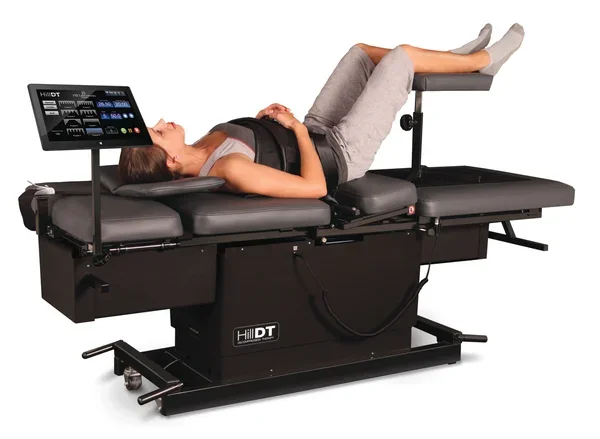 Woman lying on a medical examination and treatment table with a digital control panel.