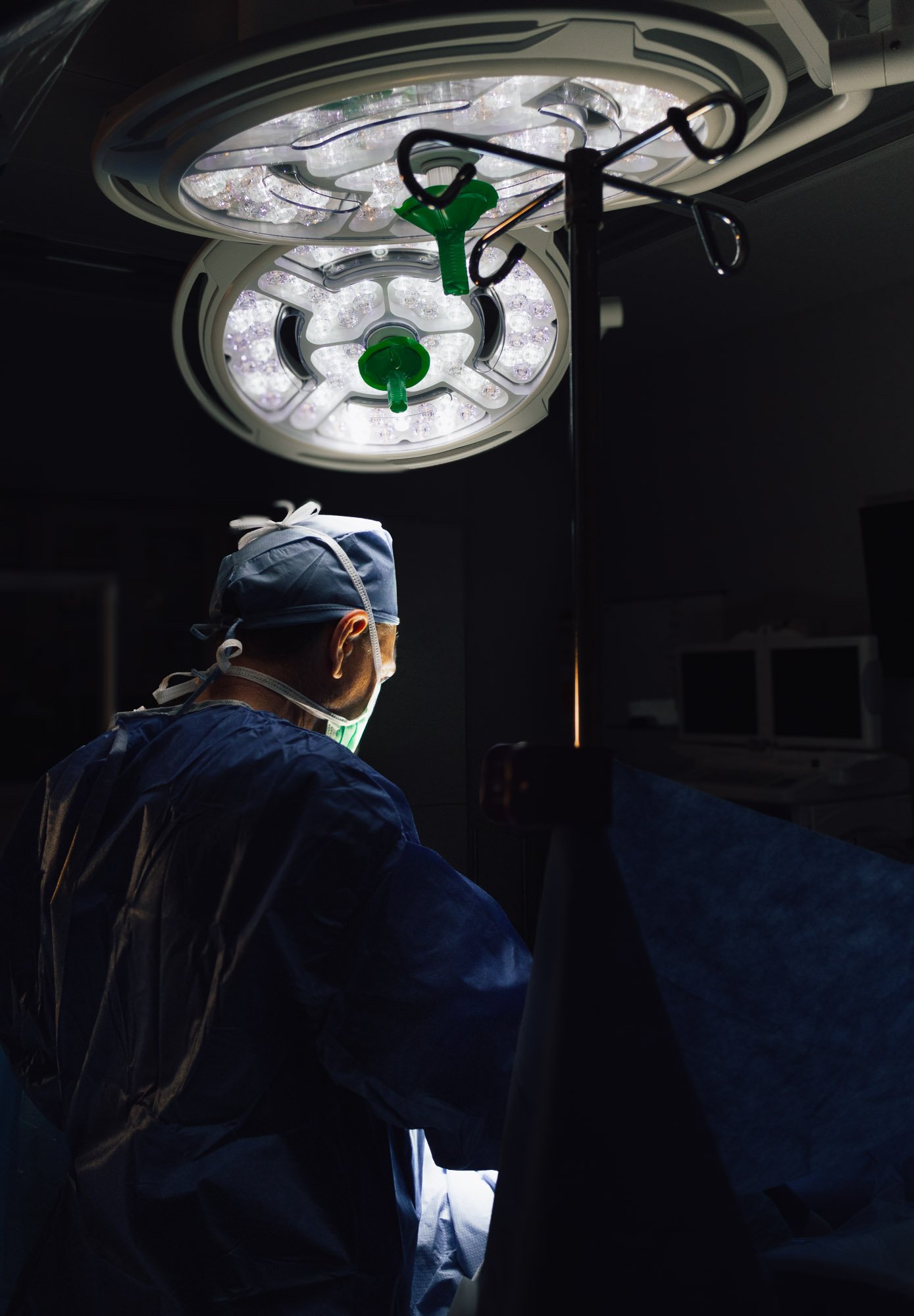 Dr. Dohring in an operating room working under bright surgical lights.