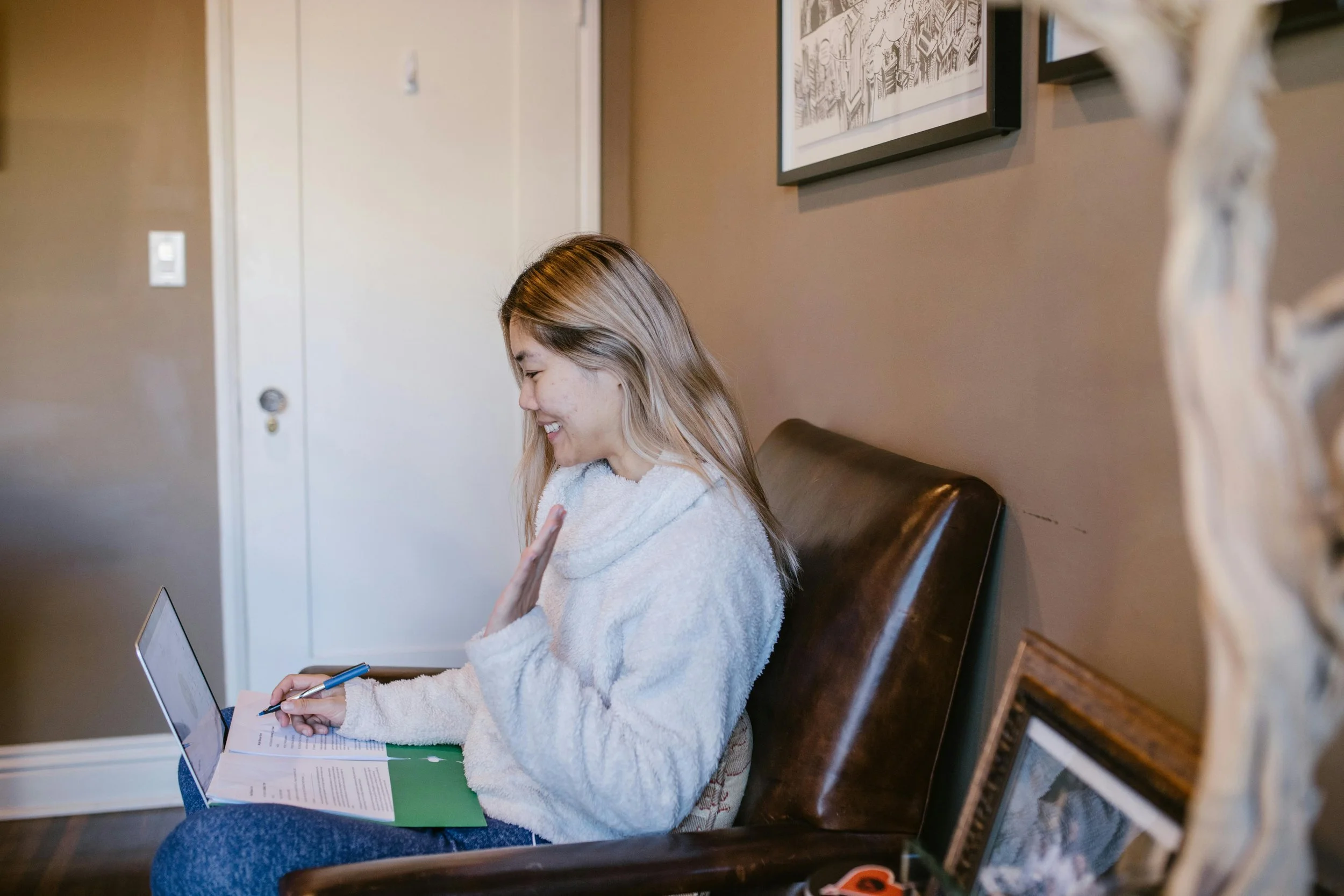 Woman smiling and waving during an online meeting from home, which is how queer black woman therapist Dr. Mary Woodson provides supervision in NC & CO.