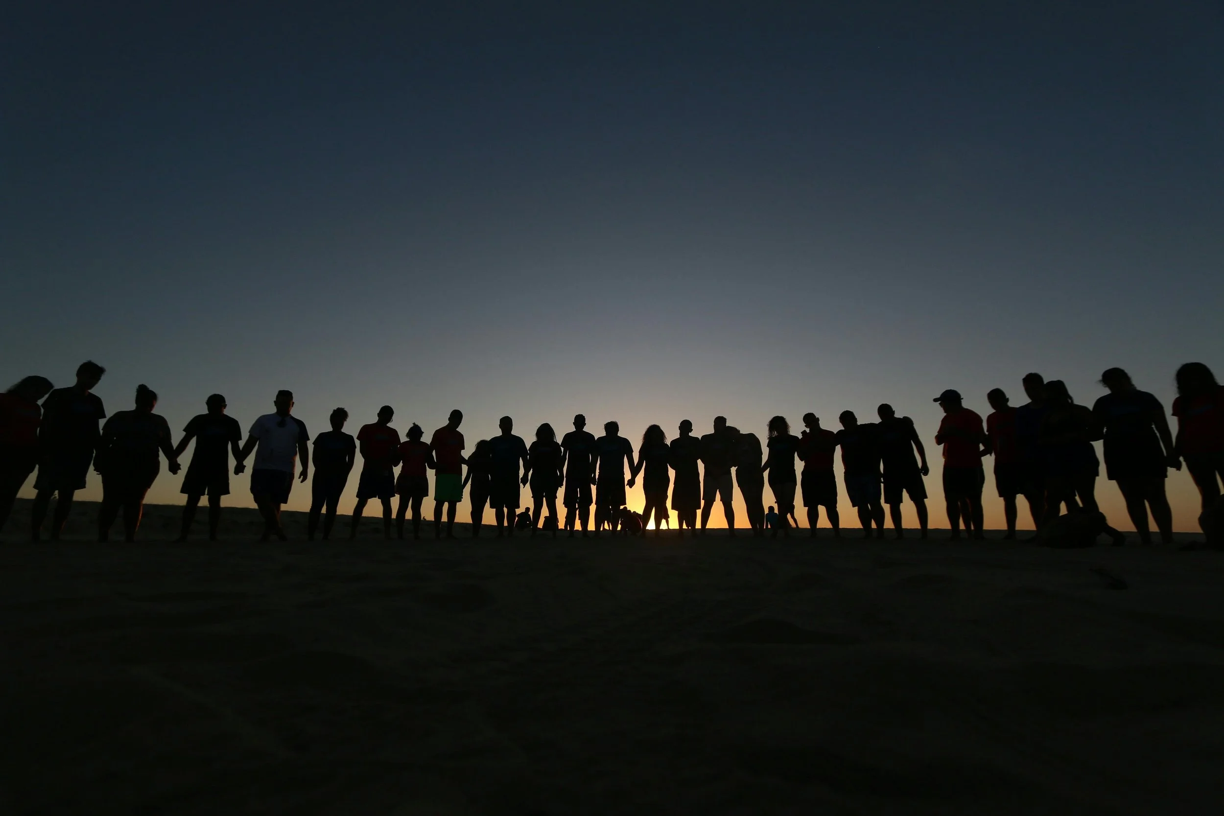 An image of diverse people standing in front of a sunset, demonstrating how black queer therapist Dr. Mary Woodson works with a wide variety if people from marginalized communnities, teens and stressed adults.