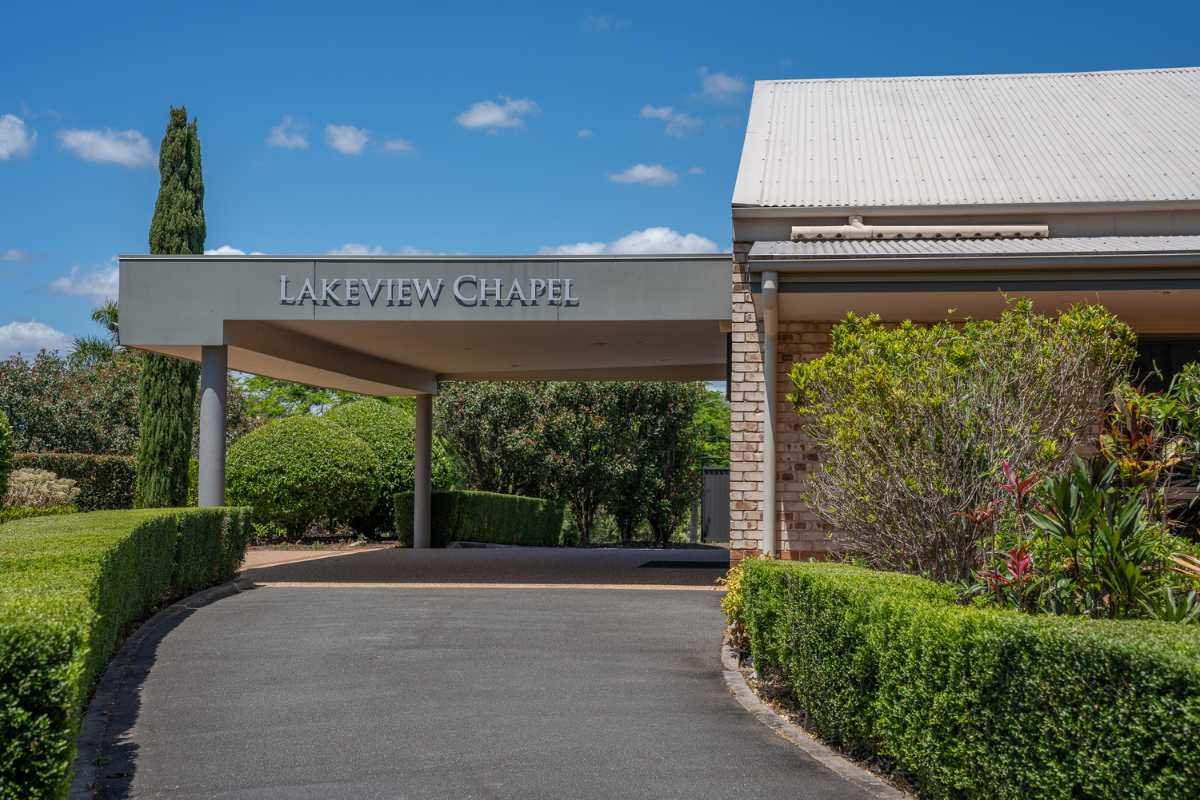 Entrance sign of Lakeview Chapel with landscaping and clear blue sky.