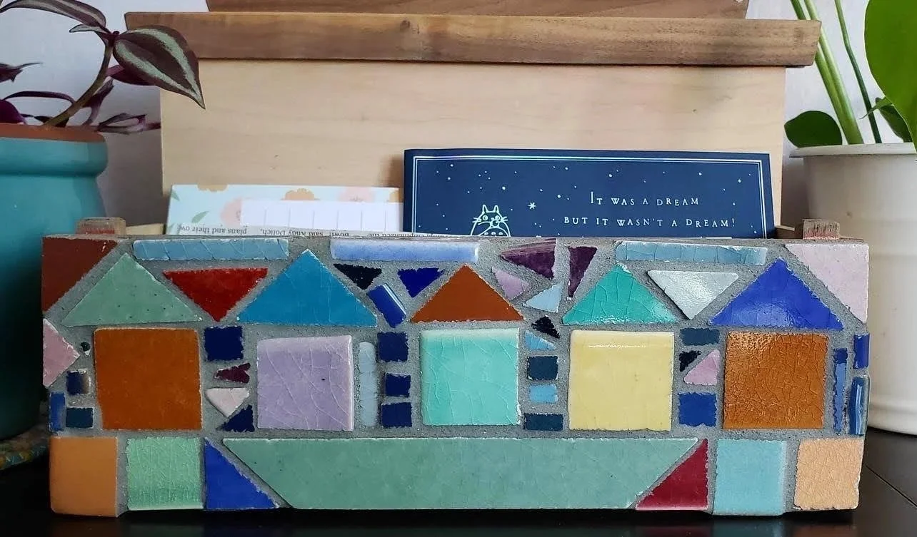 Colorful mosaic photos with a blue card and potted plants in the background.