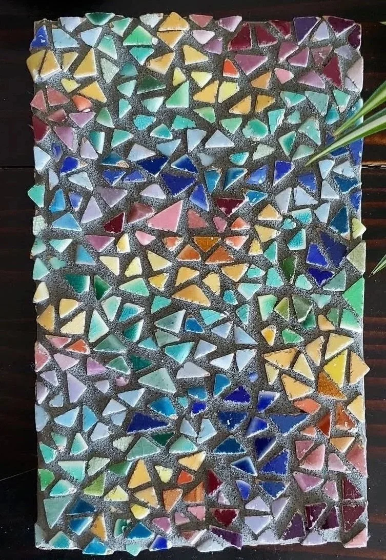 Colorful mosaic tile artwork with various shapes and colors, including blue, green, yellow, red, and purple.