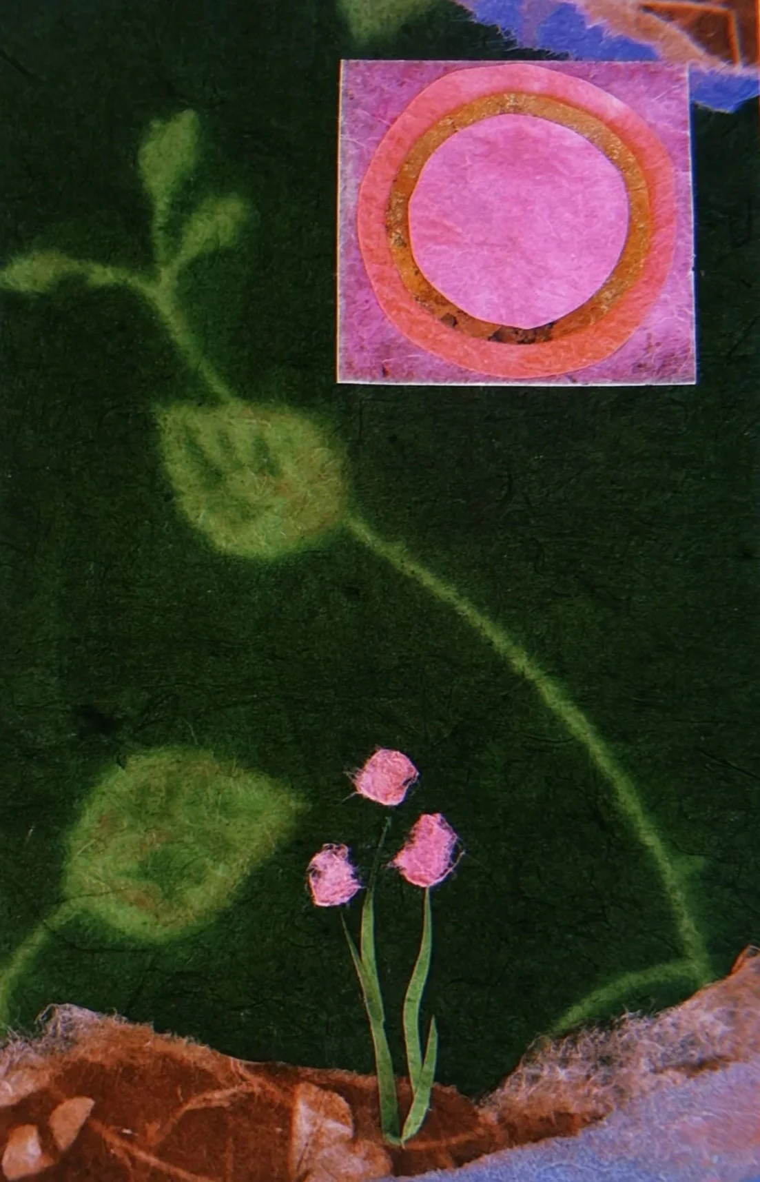 A handmade collage featuring a green leaf with three pink flowers and a pink circle with an orange border on a textured paper background.