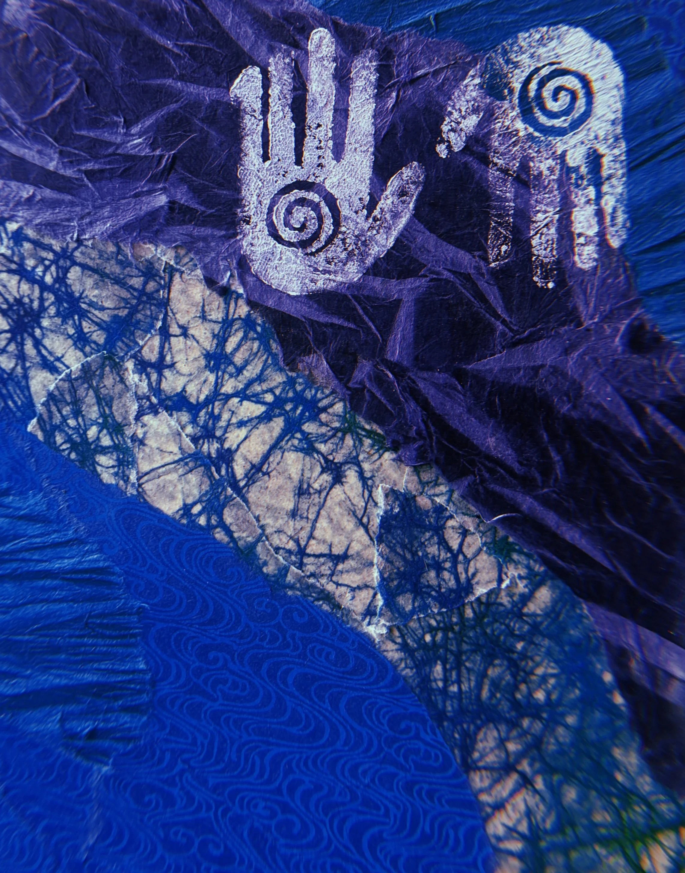 Close-up of a textured, crumpled blue and purple paper with white handprints and spiral designs.