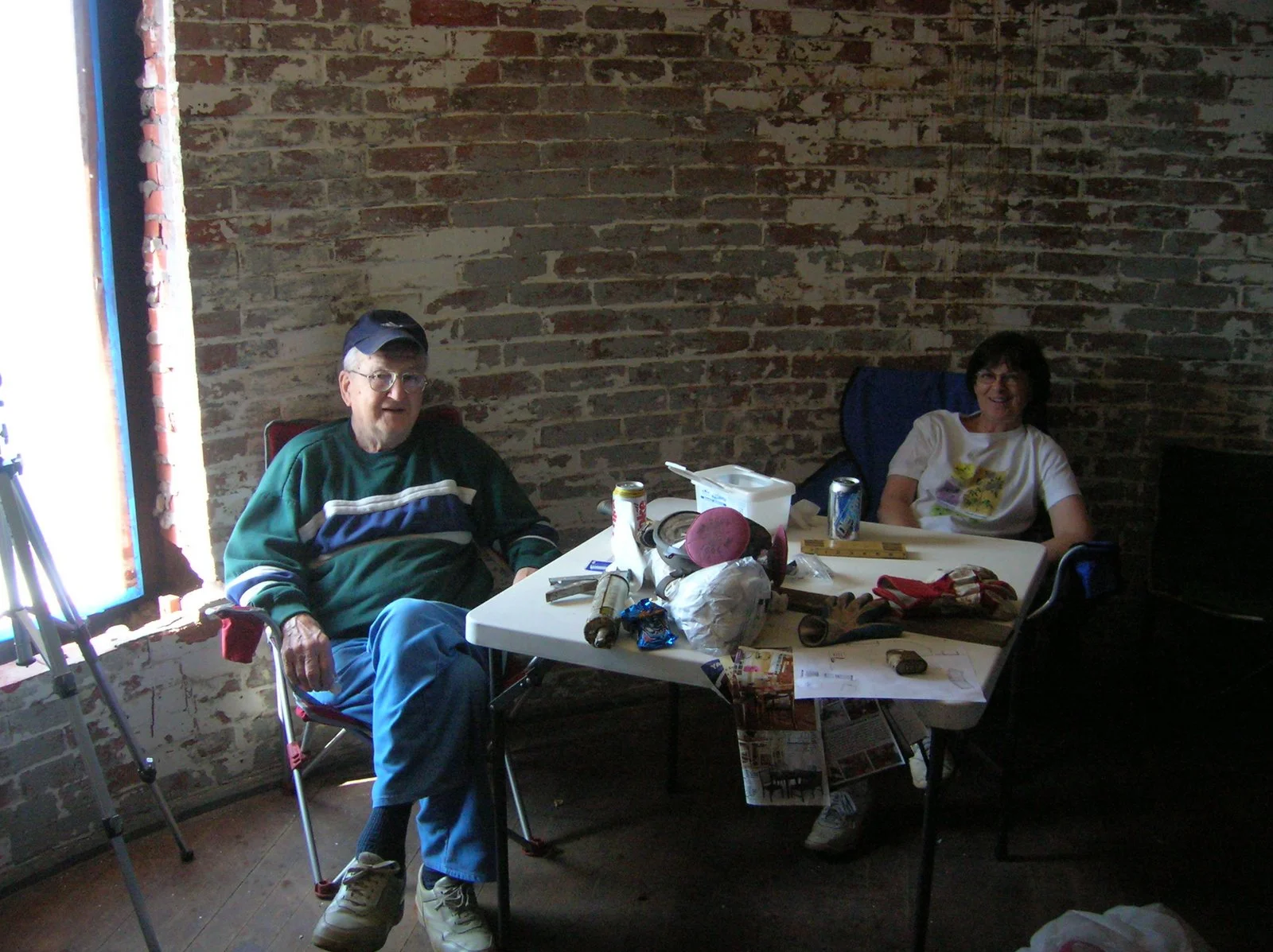 Two people sitting in the sleeping quarters on Middle Ground Lighthouse before it was renovated. 