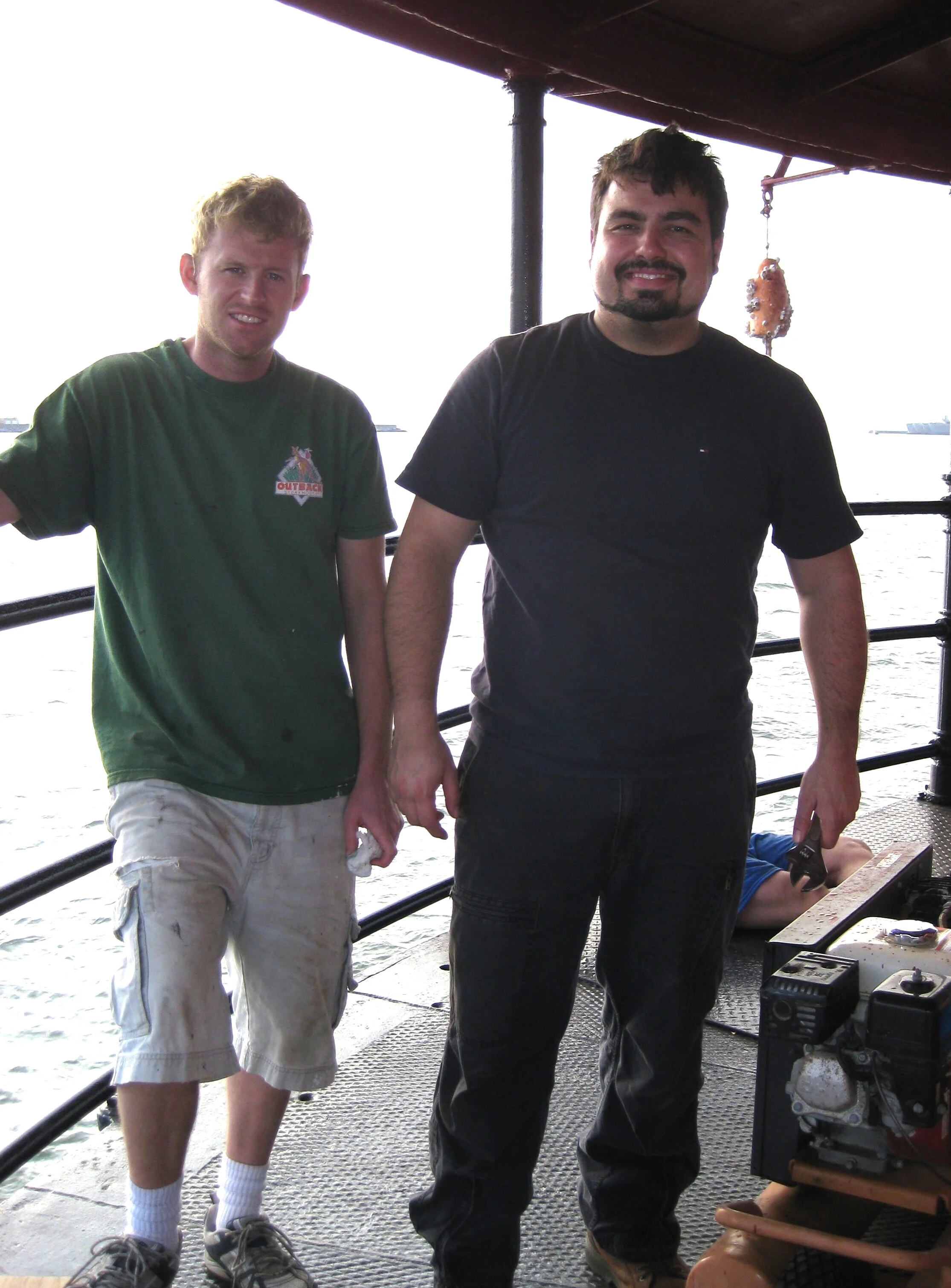 Two workers dirty from renovation work on Middle Ground Lighthouse. 