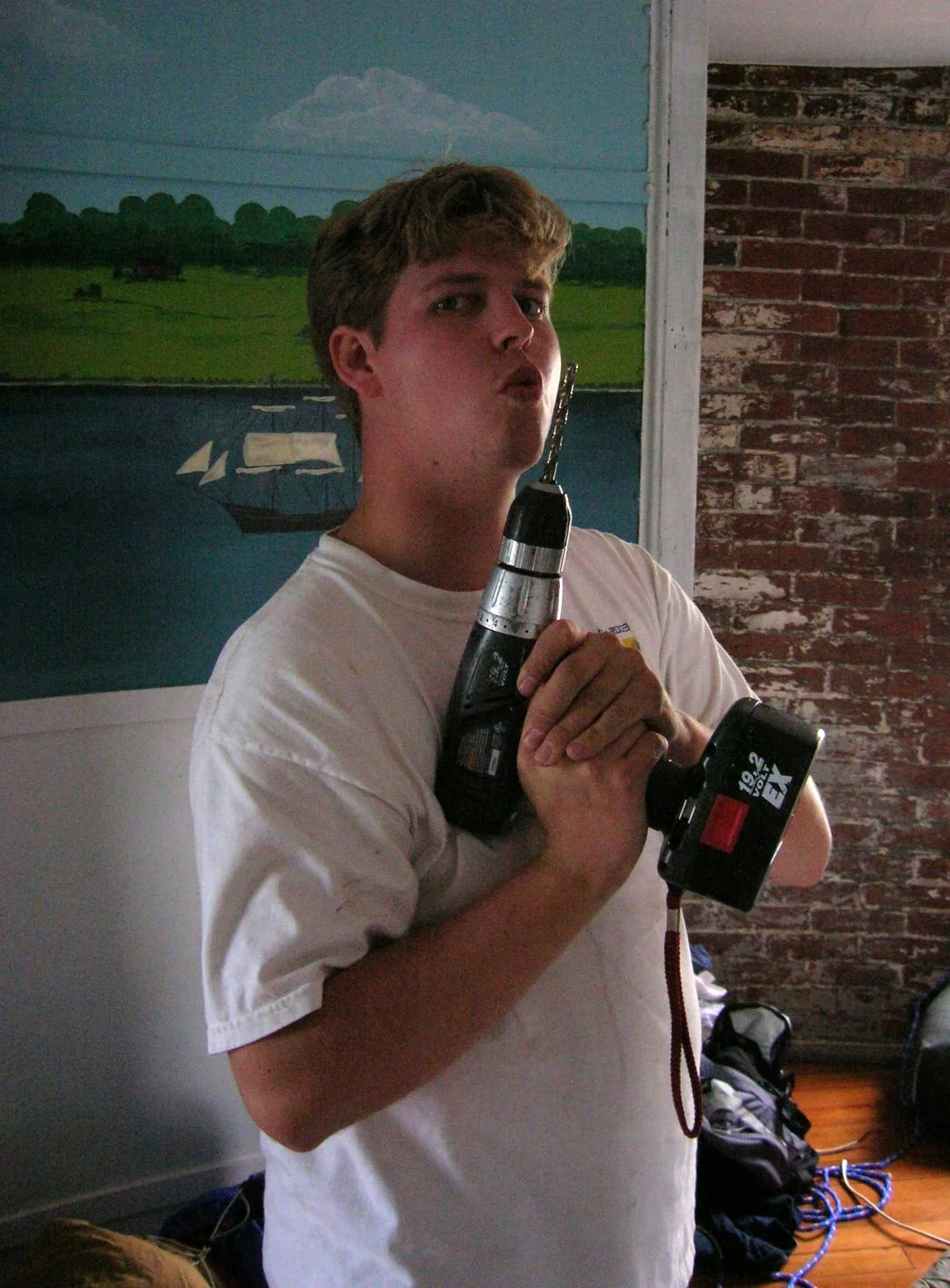 Young man with a power tool in the sleeping quarters of Middle Ground Lighthouse. 