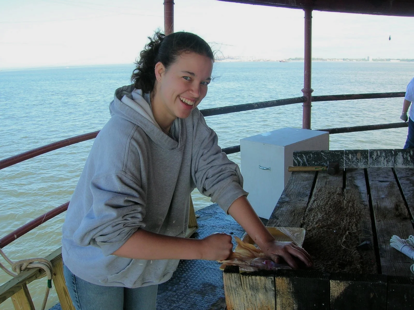 A smiling woman working on the main deck of Middle Ground Lighthouse. 