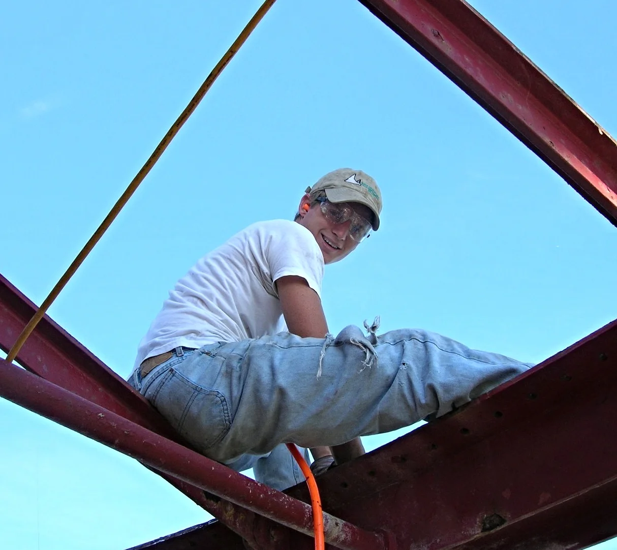 Young man wearing safety goggles while working to reinstall the main deck roof on Middle Ground Lighthouse. 