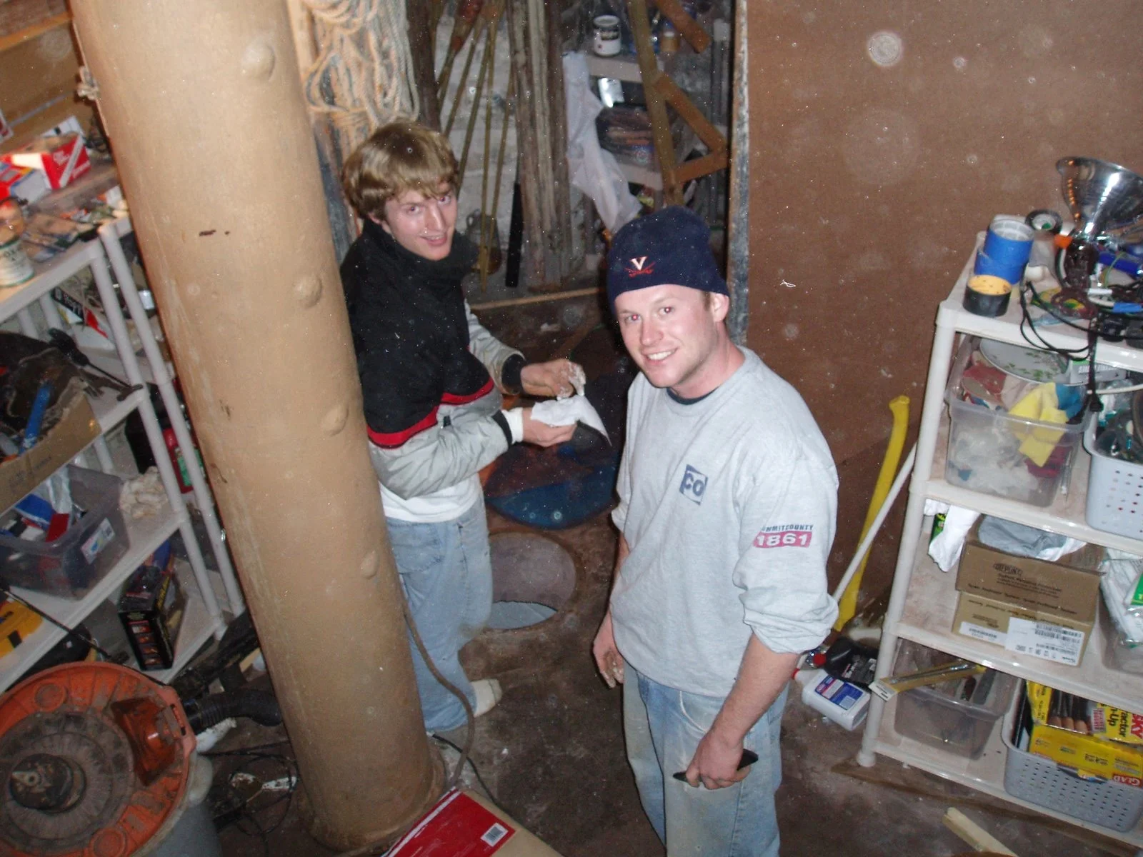 Two men are working in the cellar of Middle Ground Lighthouse, getting ready to clean out the rainwater cisterns. 