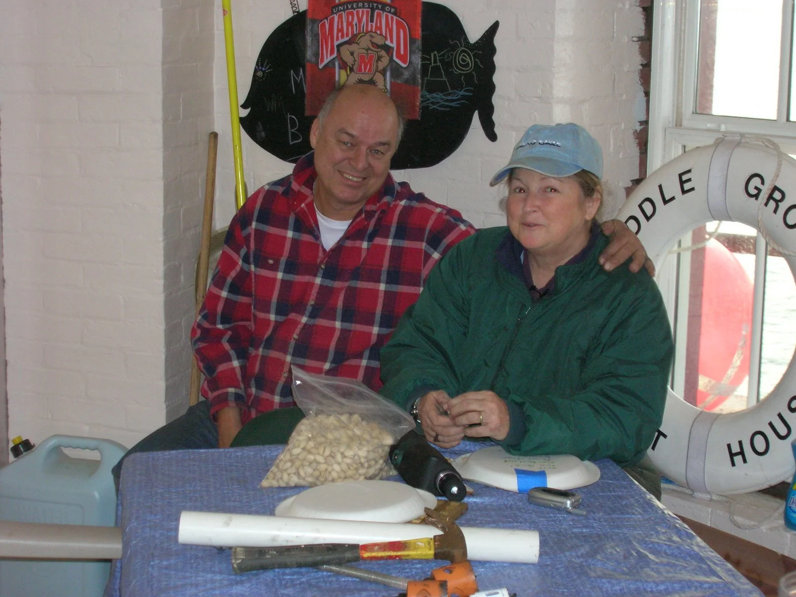 Two people smiling and posing for a photo in the kitchen of Middle Ground Lighthouse. 