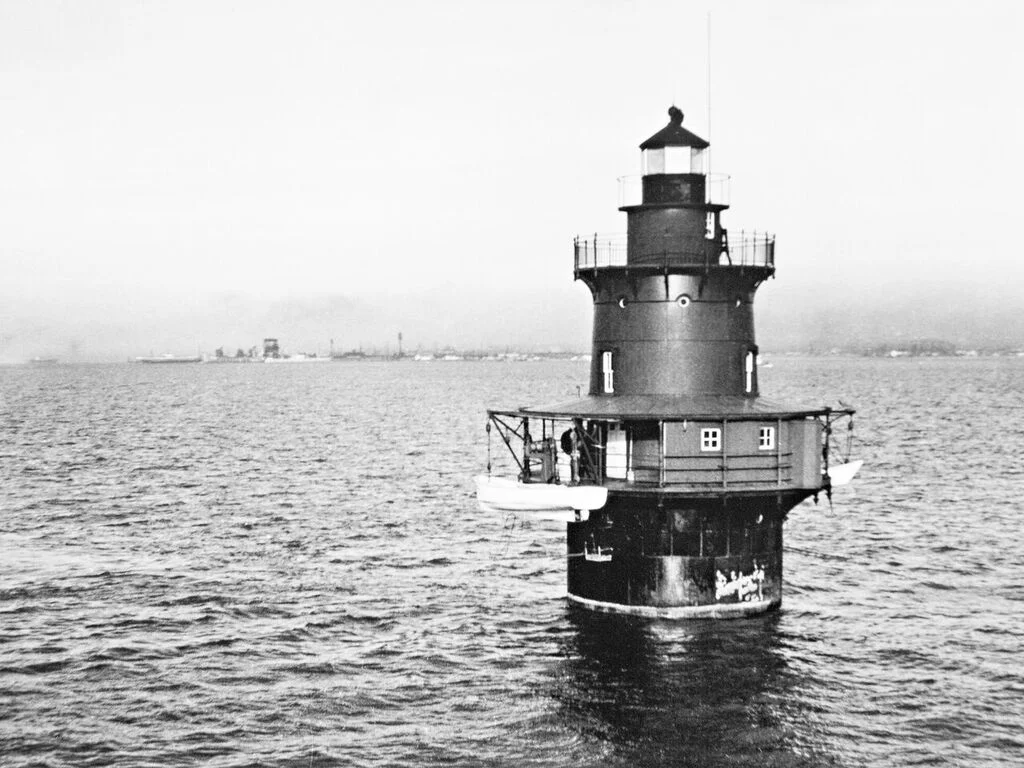 Historical black and white photo of Middle Ground Lighthouse on the water with Hampton Roads in the background.