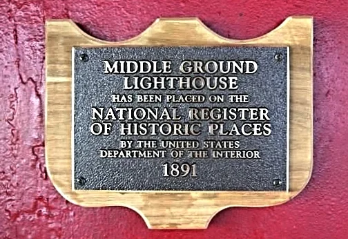 Plaque on a red wall indicating Middle Ground Lighthouse on the National Register of Historic Places since 1891.