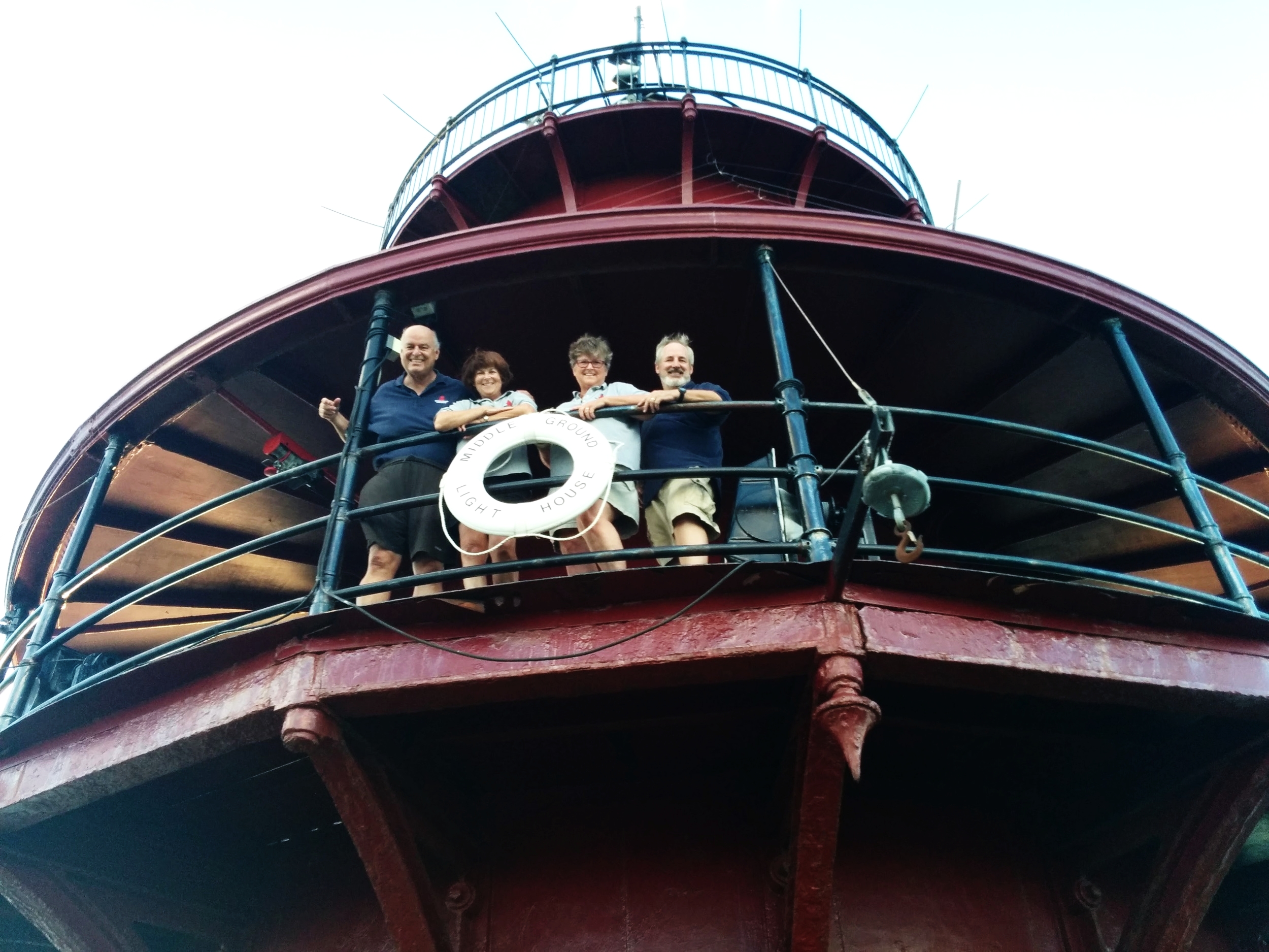 Private ownership on the balcony of Middle Ground Lighthouse, smiling and posing for the photo.