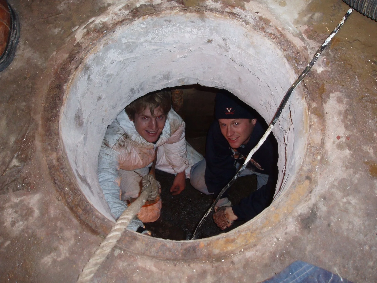 Two men cleaning the inside of the cellar cisterns on Middle Ground Lighthouse. 