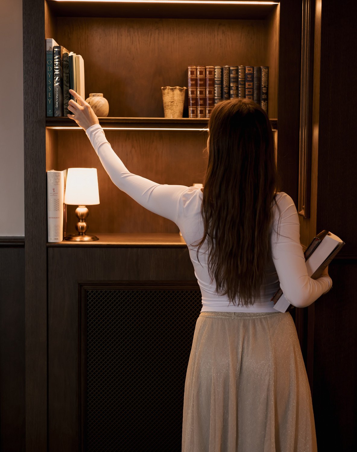Rachelle Hicks selecting a book while researching astro mythology and symbolic storytelling