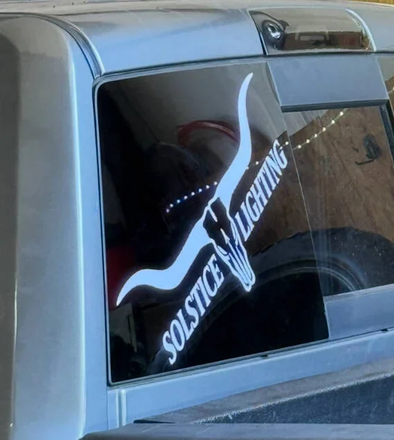 Car with a decal of a longhorn and the words 'Solstice Longhorn' on the rear side window.