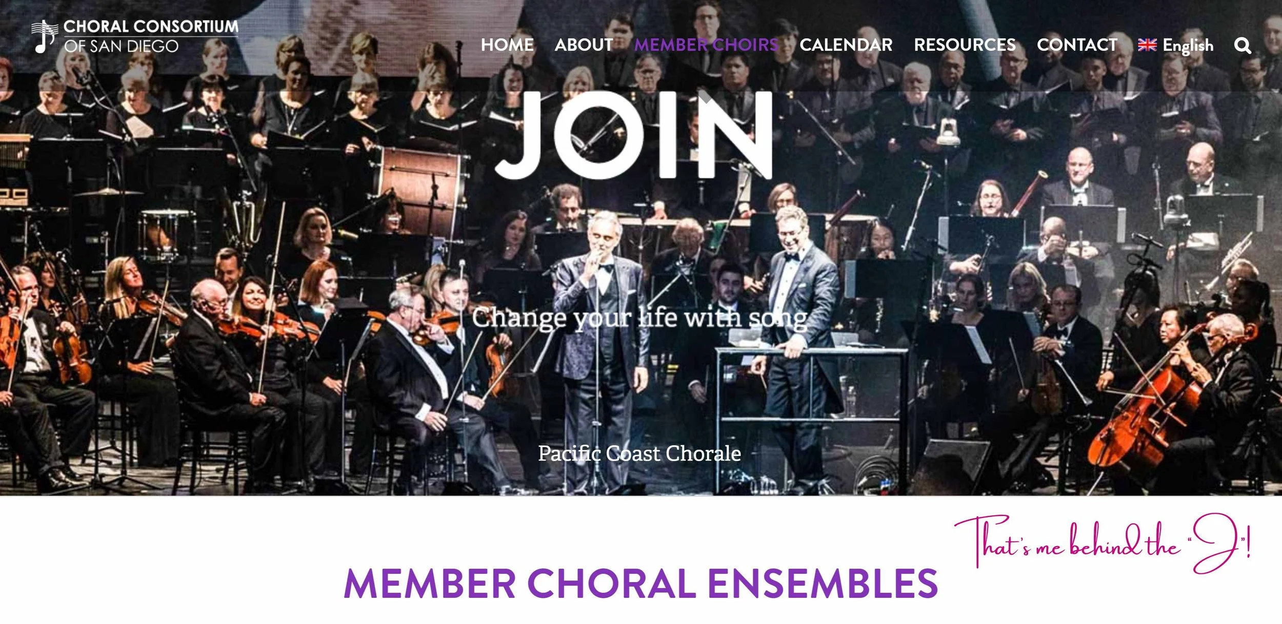 A large choir and orchestra performing on stage, with men in tuxedos and women in black dresses, led by conductors, with the banner of the Pacific Coast Chorale in the background.